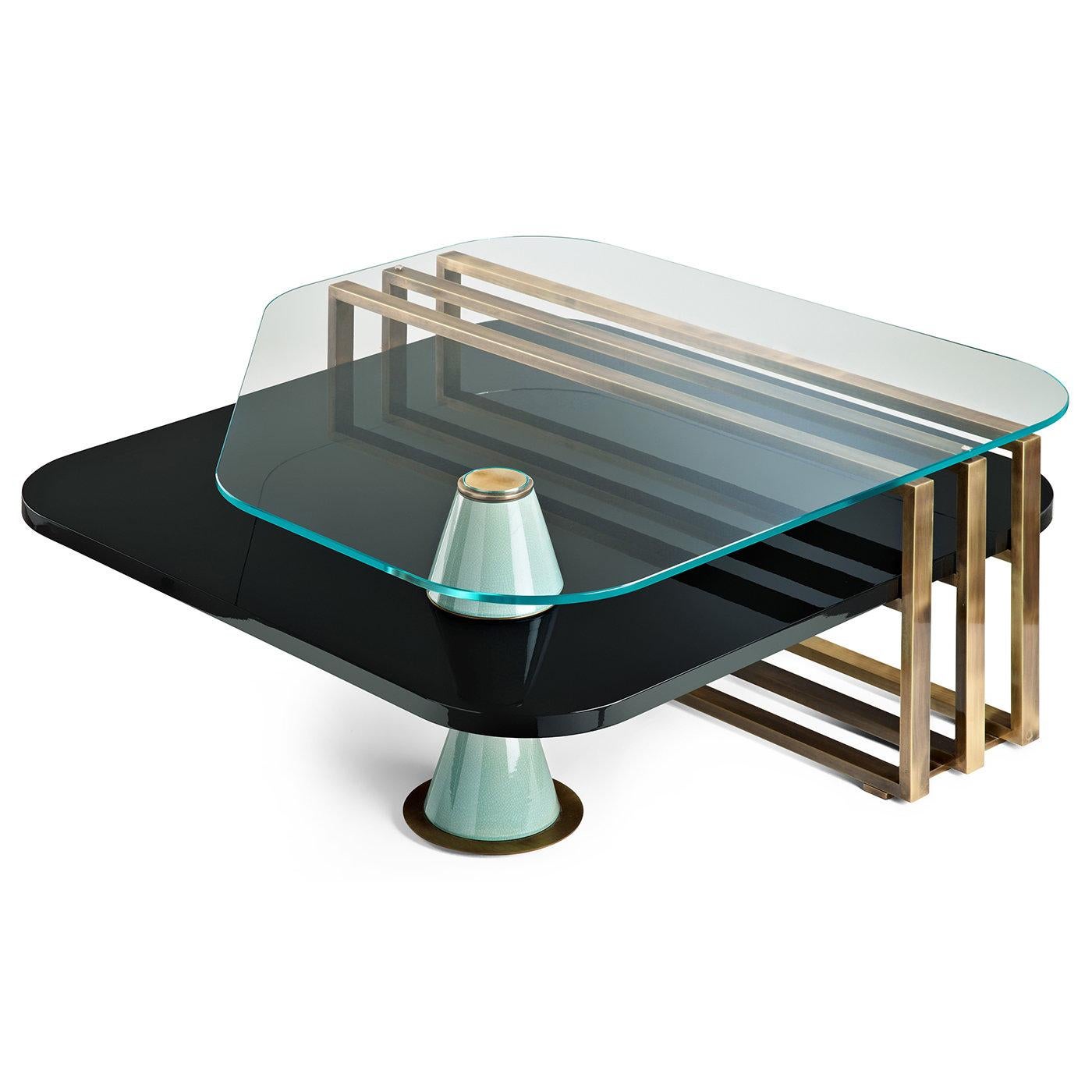 This elegant coffee table designed by Piero Angelo Orecchioni for Marioni features a lower shelf in black-lacquered wood surmounted by a clear glass top. The two layers are separated by three brushed brass bars wrapping around one side of the table