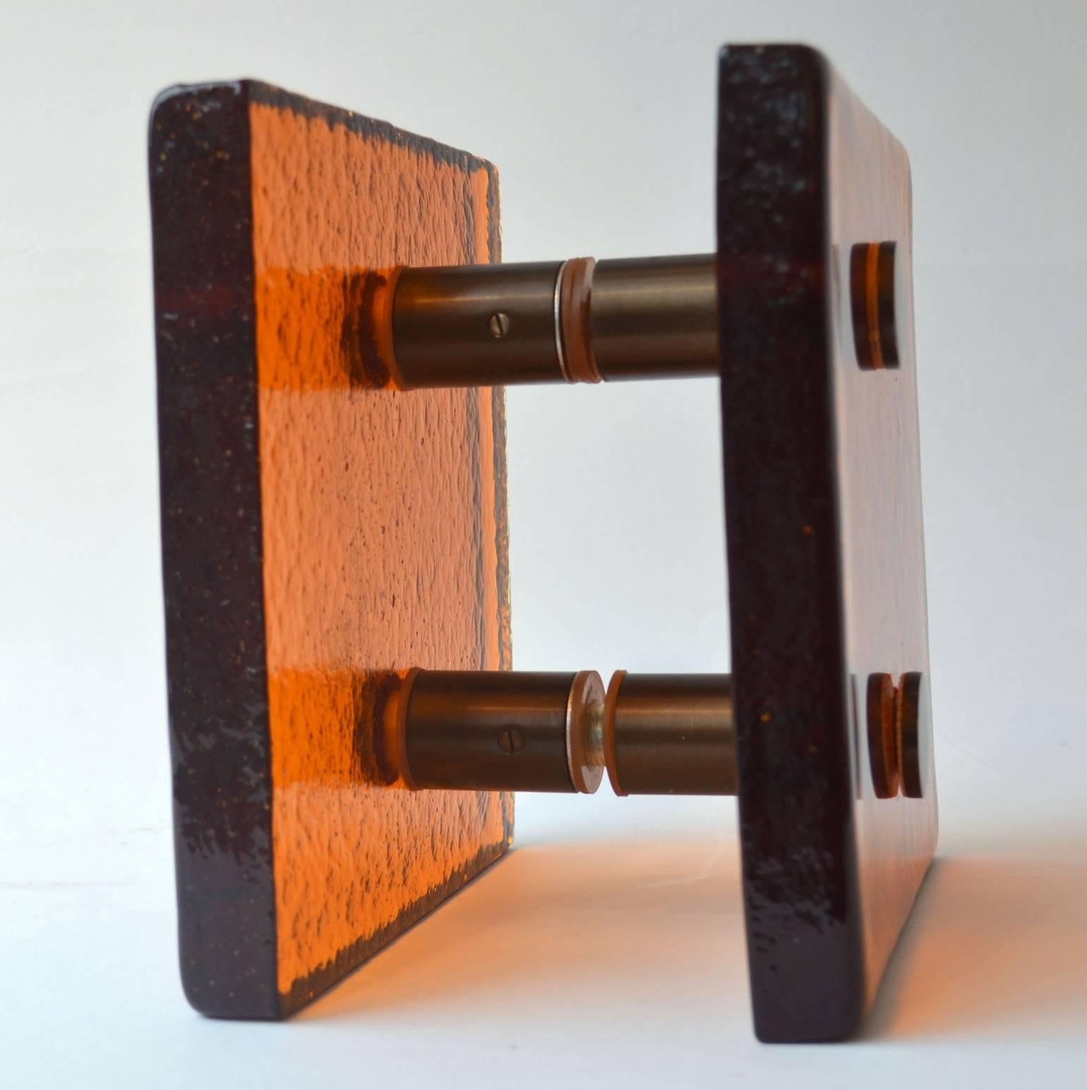 Orange glass cast square glass push and pull door handle with brass fittings designed for a glass door, French 1960's.
The fixings can be adjusted for wooden doors.

Thickness of the glass; 25 mm
Distance of spacer between the glass and door; 40 mm