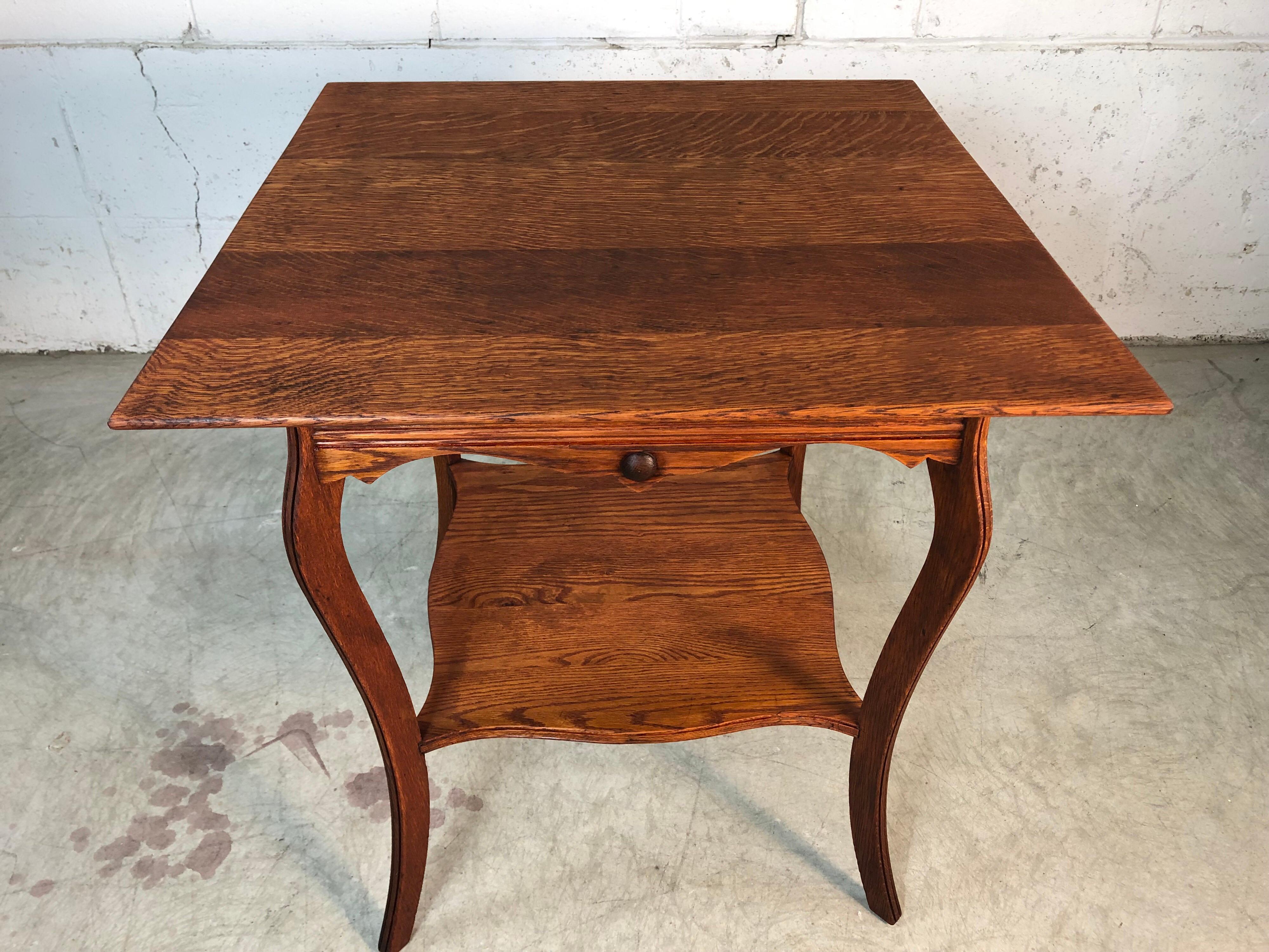 Portapiante o tavolino vintage a due livelli in rovere segato a quarto d'altezza. Il tavolo ha gambe in stile cabriole con un accento incanalato che corre lungo i lati, le gambe e il ripiano inferiore. Il tavolo è stato appena rifinito. Nessun