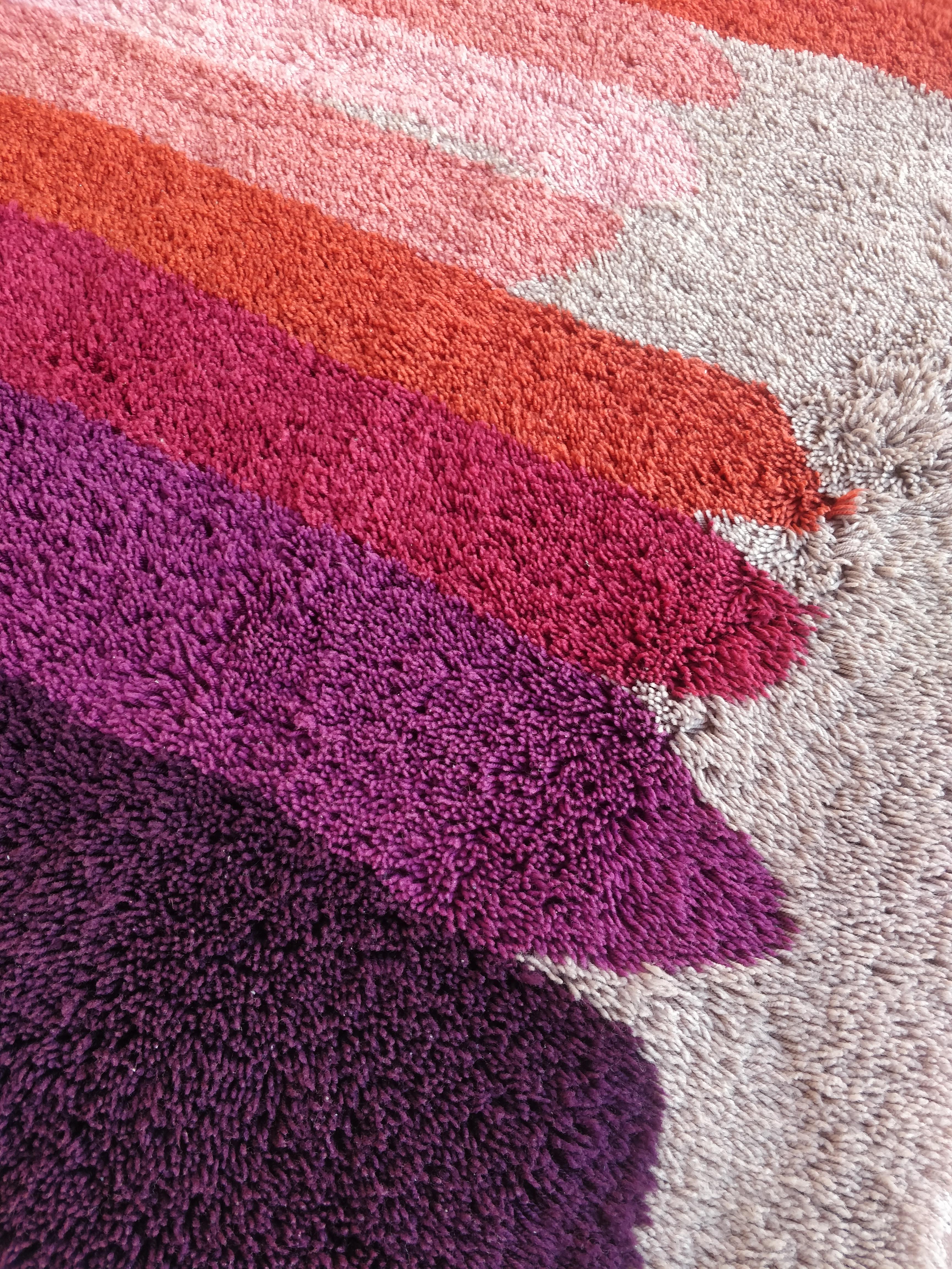 
Ce tapis vintage des années 1970, produit par Desso aux Pays-Bas, est une pièce emblématique du design pop art de l'époque. Avec ses poils hauts et son fond blanc, il crée une base lumineuse et épurée. Avec un design moderne aux rayures colorées,