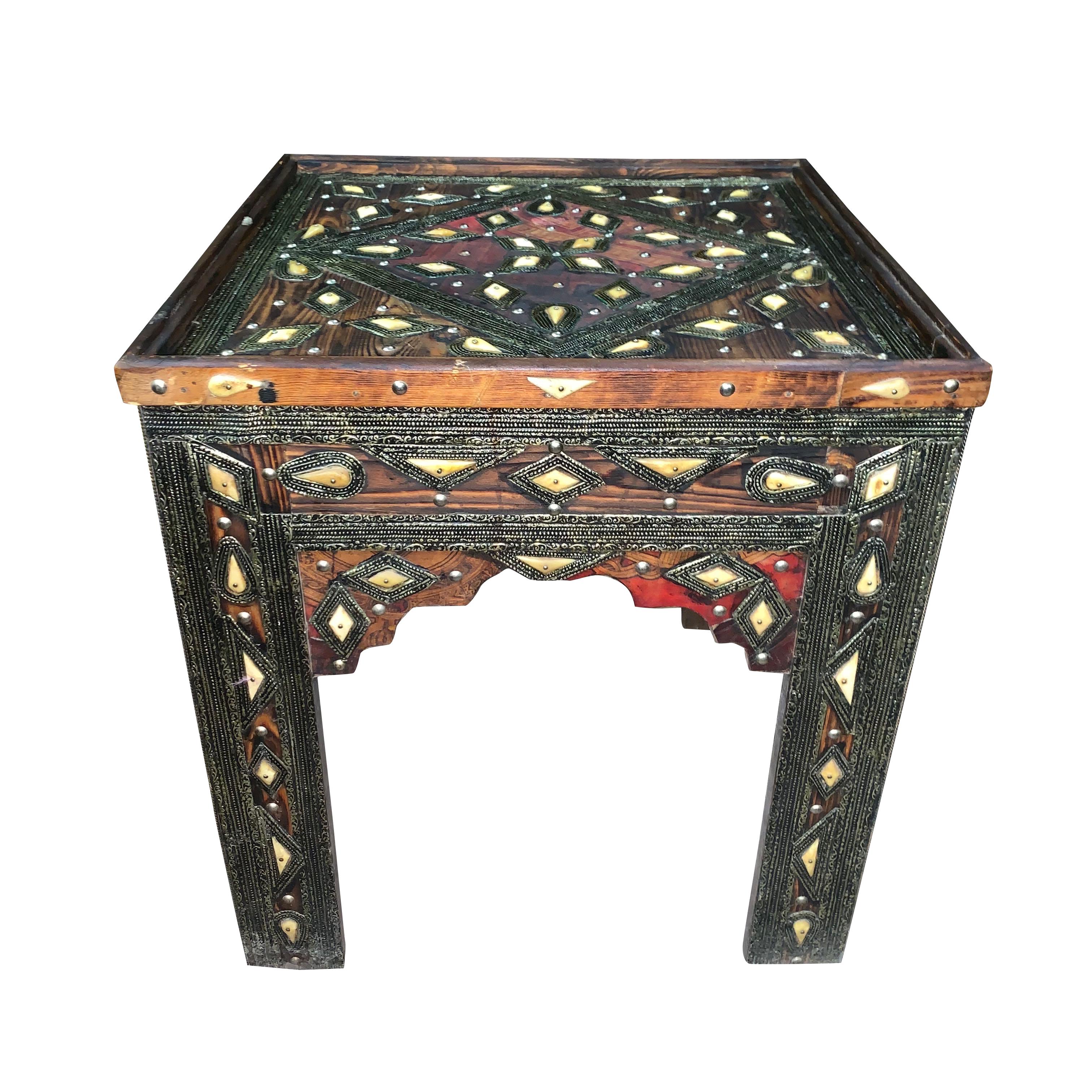 1920s from the Oujda region of Morocco a glass top square side table.
Decorative bone and silver inlay details throughout the table.
Henna dyed goatskin accents on cedarwood.
