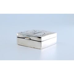 Square silver pill box with plant motifs engraved on the hinged lid