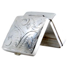 Square silver pill box with plant motifs engraved on the hinged lid