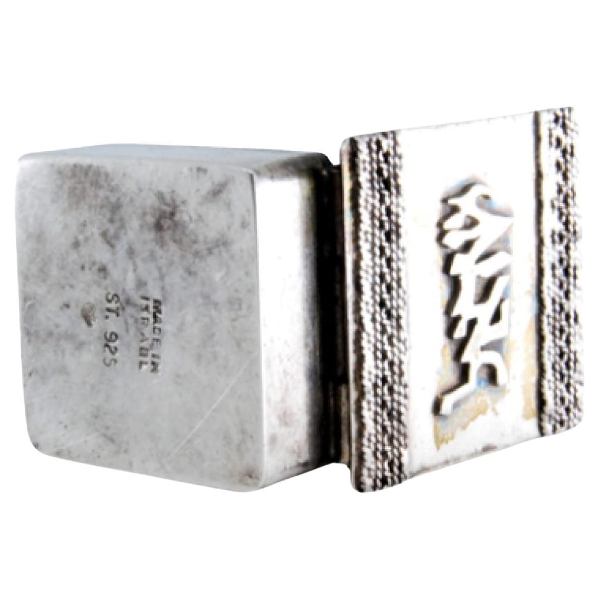 Square silver pill box with raised applications on the hinged lid