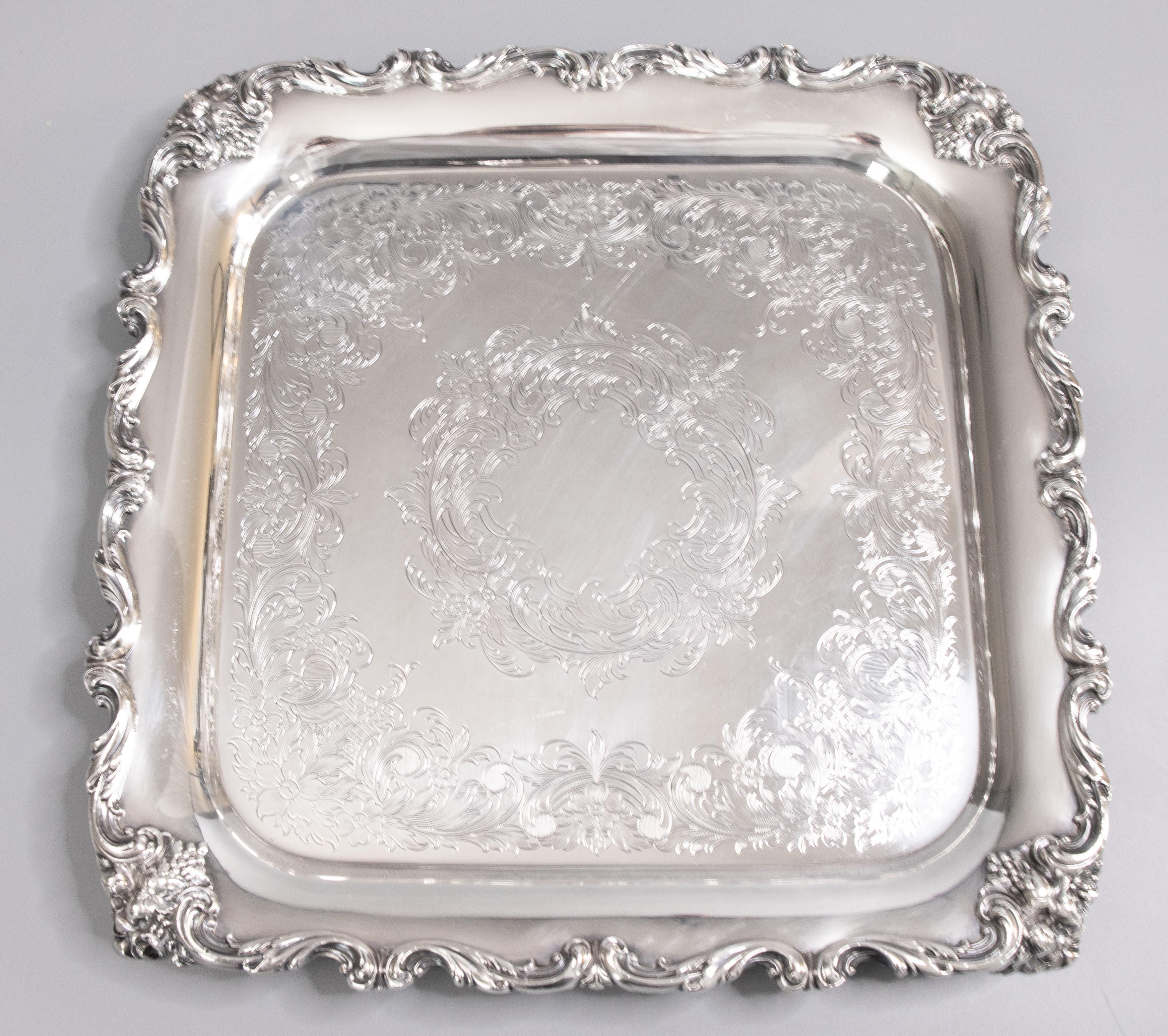 A lovely midcentury silverplate footed serving tray by International Silver Co. Maker's mark on reverse. This fine quality silver tray is well made and heavy with gorgeous chasing, an ornate scrolling grape vine border, and floral garland decorative