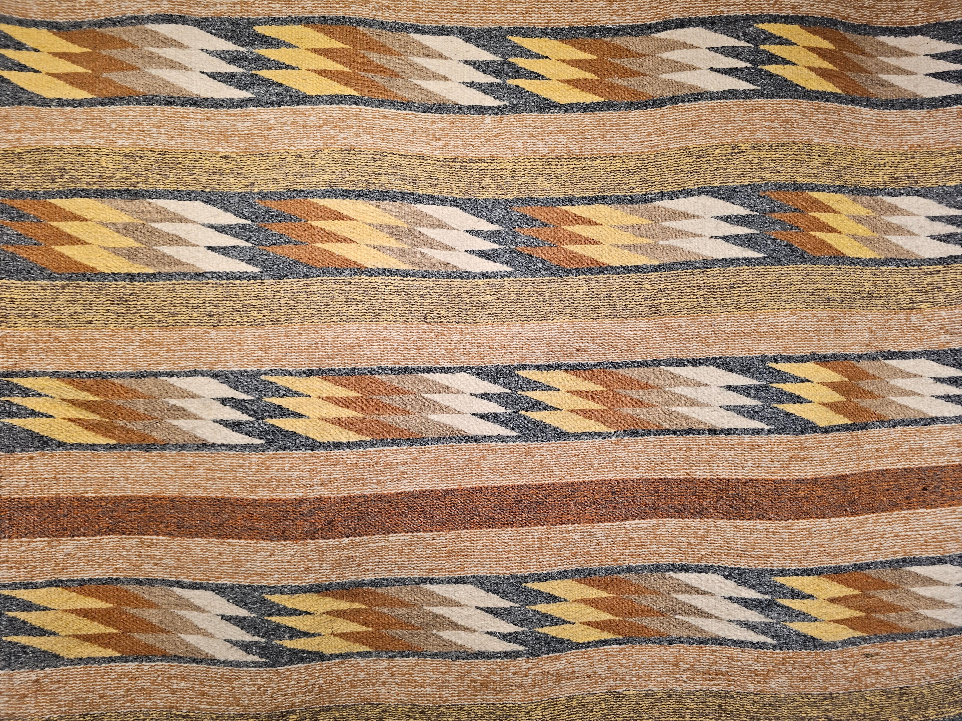  Extremely rare and very desirable square size vintage native American Navajo rug hand-woven in the Southwestern part of the United States in the 3rd quarter of the 1900s.   The eye dazzling design pattern in rows separated with solid stripes.   The