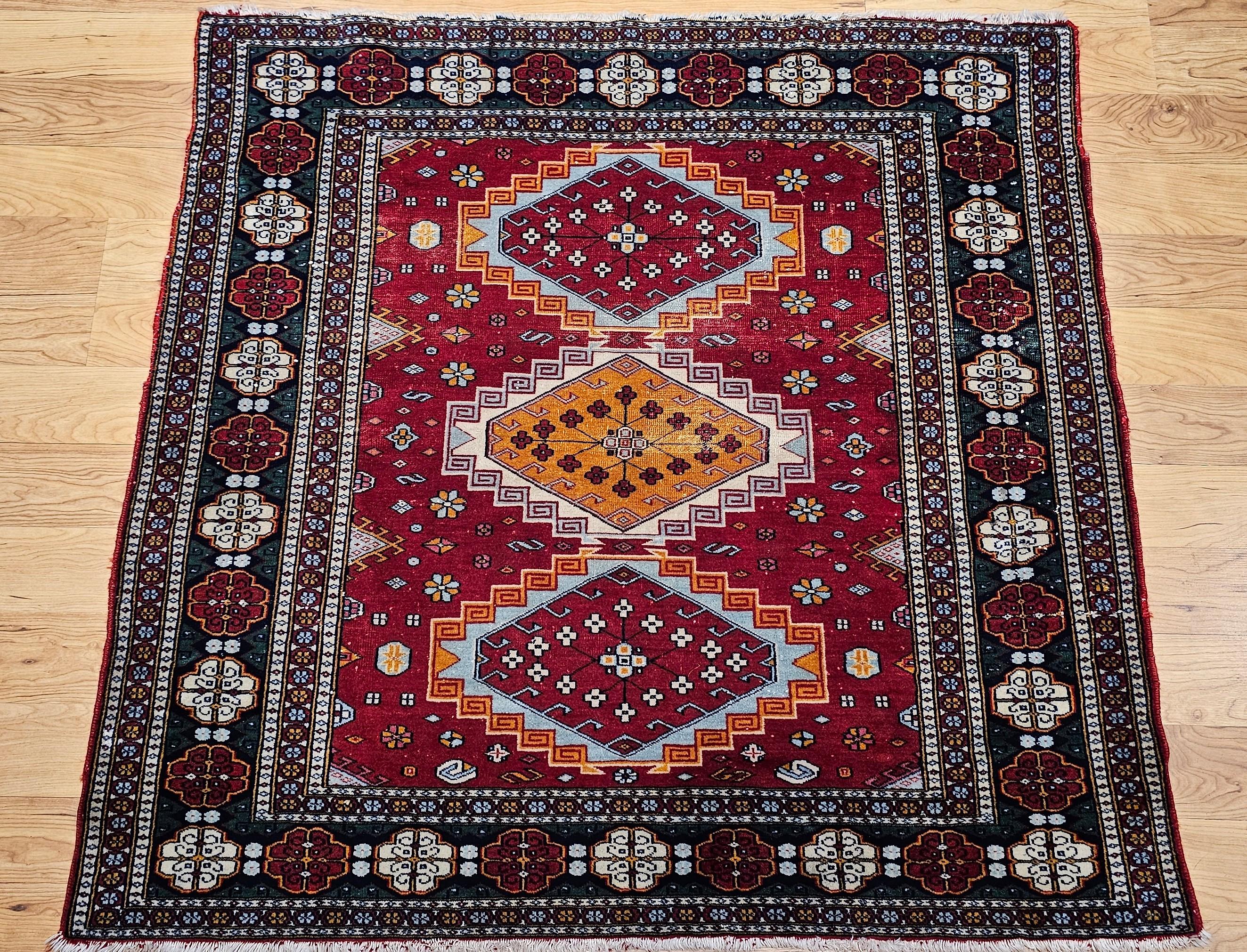 Muy deseable alfombra tribal persa de tamaño cuadrado en un brillante color rojo de fondo con medallones en marfil, azul real, amarillo y azul marino de mediados del siglo XX.  Un diseño de medallón triple en colores azul real y amarillo sobre un