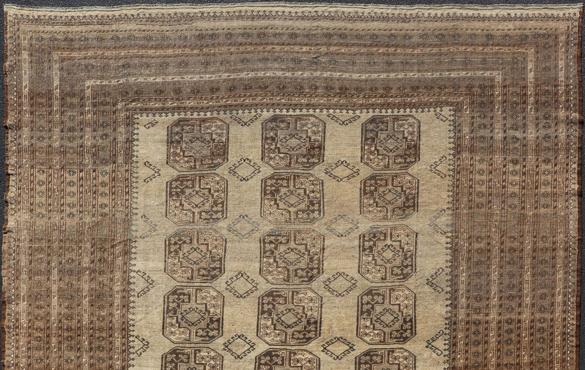 This square sized Ersari rug has been hand-knotted in the finest wool. The rug features an all-over sub-geometric repeating Gul design throughout the entirety of the rug, enclosed within a complementary, multi-tiered border, depicting small