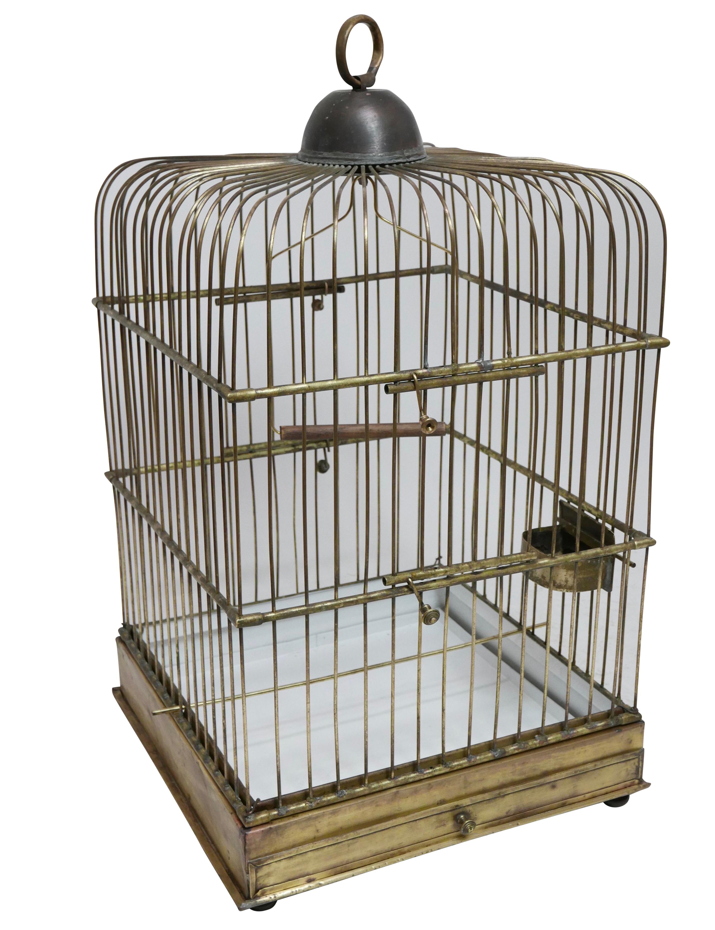 A solid brass parrot birdcage, having dual access doors, a center swing and several stationary perches along with brass twin bowl feeder and a pull out / pull-out drawer, sitting on four bun feet,
late 19th century.