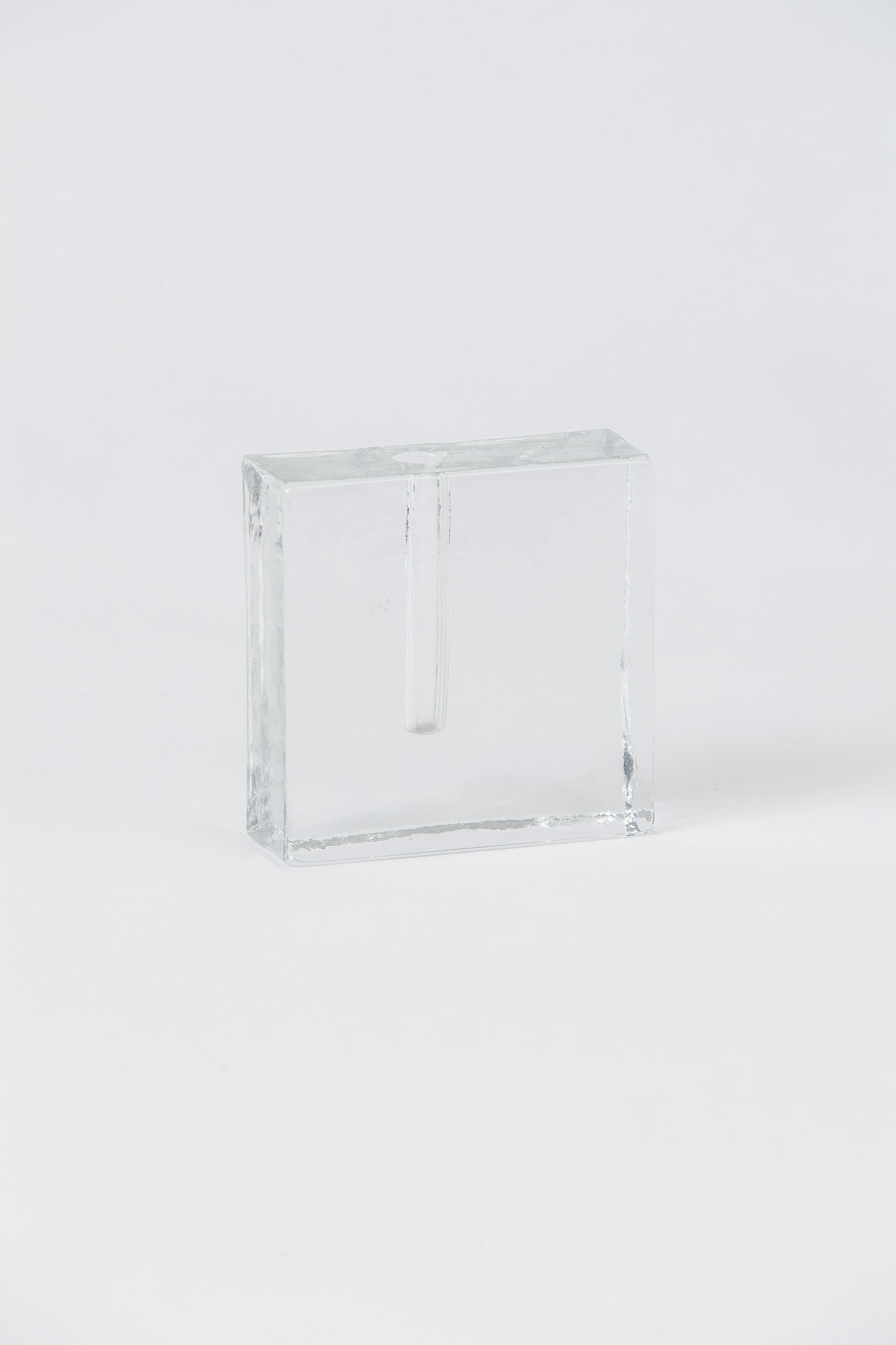 A striated solid glass square bud vase in excellent condition.
