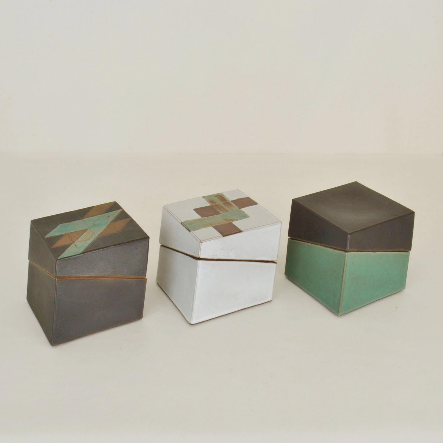 Three geometric leaning square studio pottery boxes glazed in black and white. Sculptural square studio pottery boxes, signed PS. The geometric design is emphasised by the angled openings. The lids fit precisely on the bases of the late 20th century