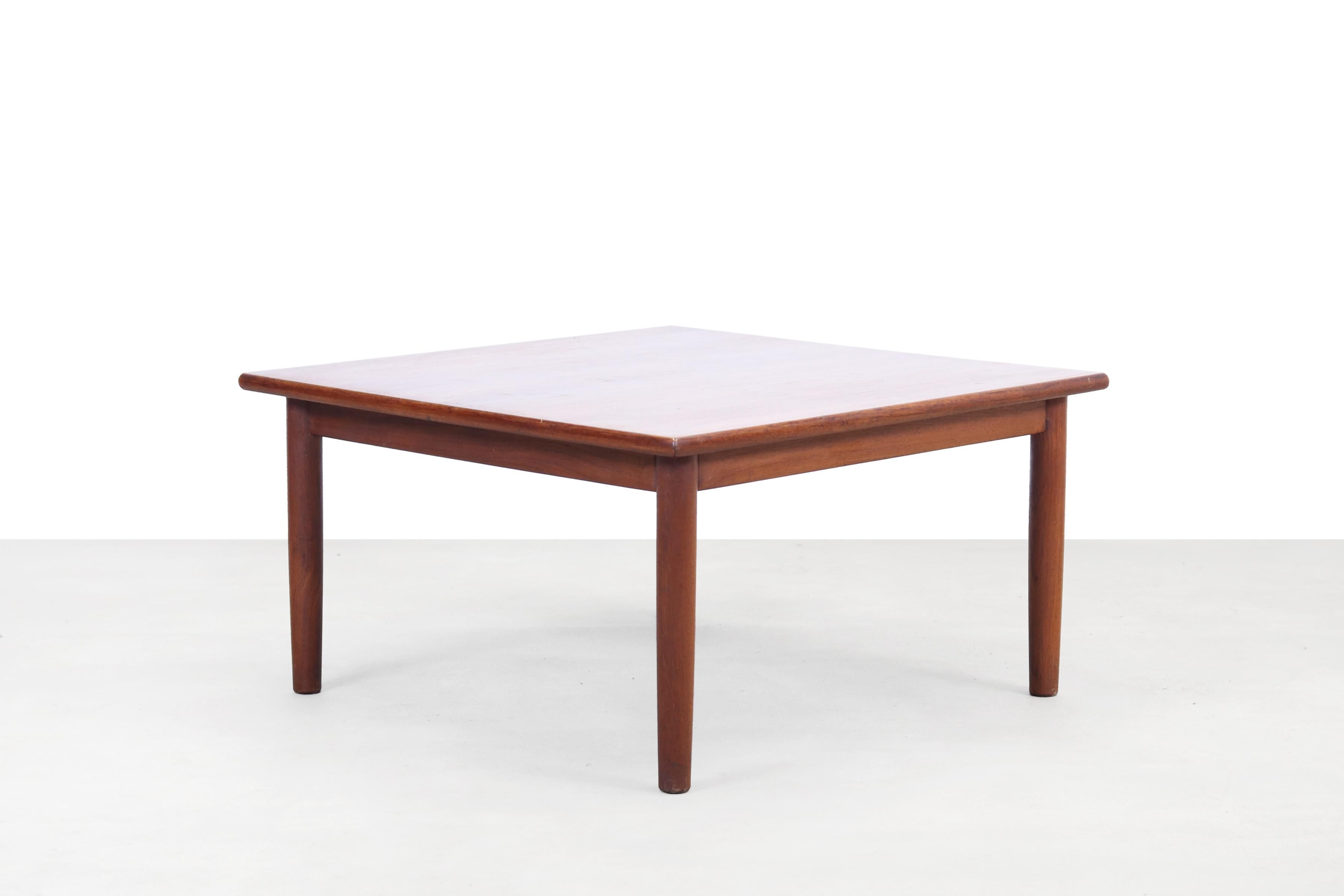 Square coffee table made of solid wooden legs with a teak veneered top. This square table is the perfect solution for a modern corner sofa. Or place it in the corner of two straight sofas to create a corner sofa.