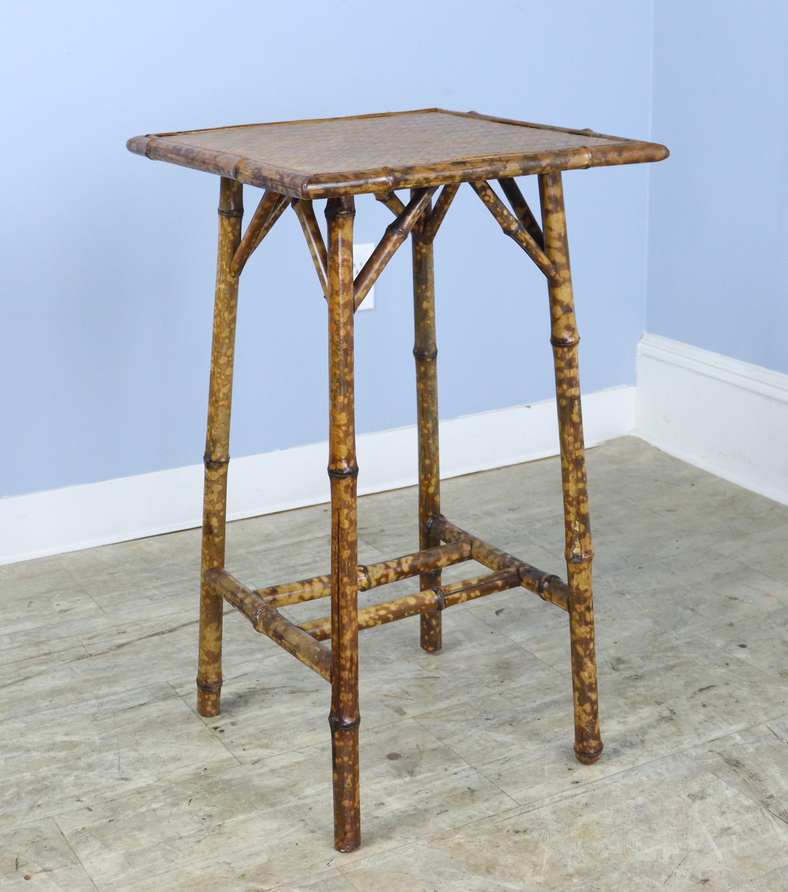 A charming bamboo side table with square top made of rattan in very good condition. Sturdy, and the bamboo is vibrantly colored and well constructed.