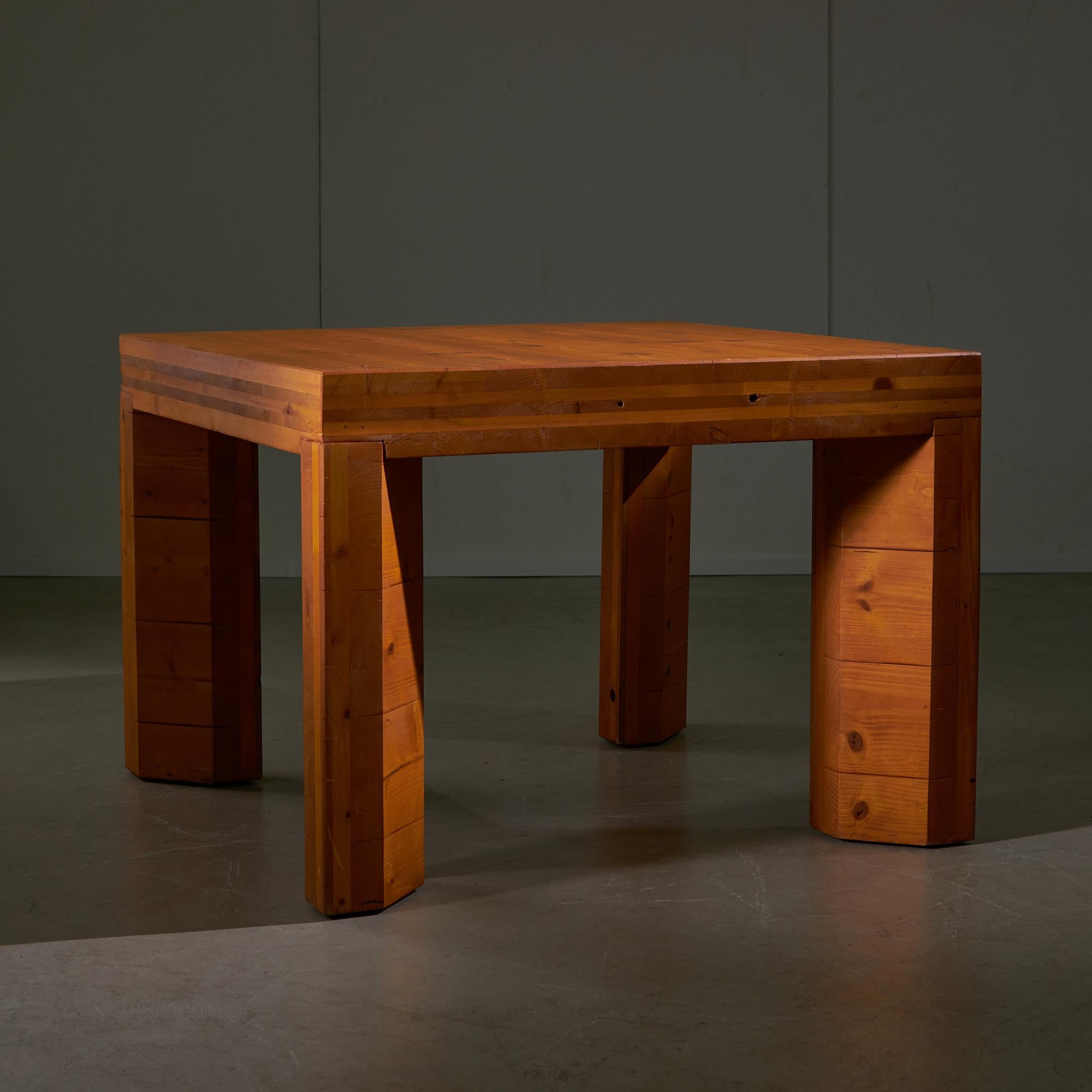 La table est dotée d'un plateau carré en pin qui offre une surface robuste et fonctionnelle, complétée par des pieds hexagonaux robustes, également en pin, qui introduisent un élément géométrique et renforcent la stabilité. Ses tons de bois chauds