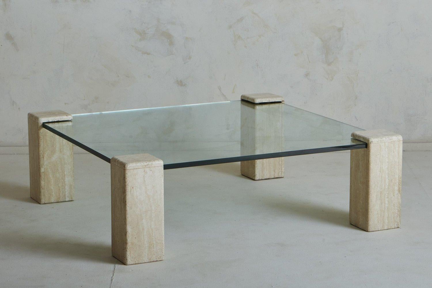 A 1970s German coffee table featuring four travertine block legs with beautiful taupe and cream veining. This stately table has a .75” thick glass top, whose corners insert within the block legs. Unmarked. Sourced in Belgium, 1970s.