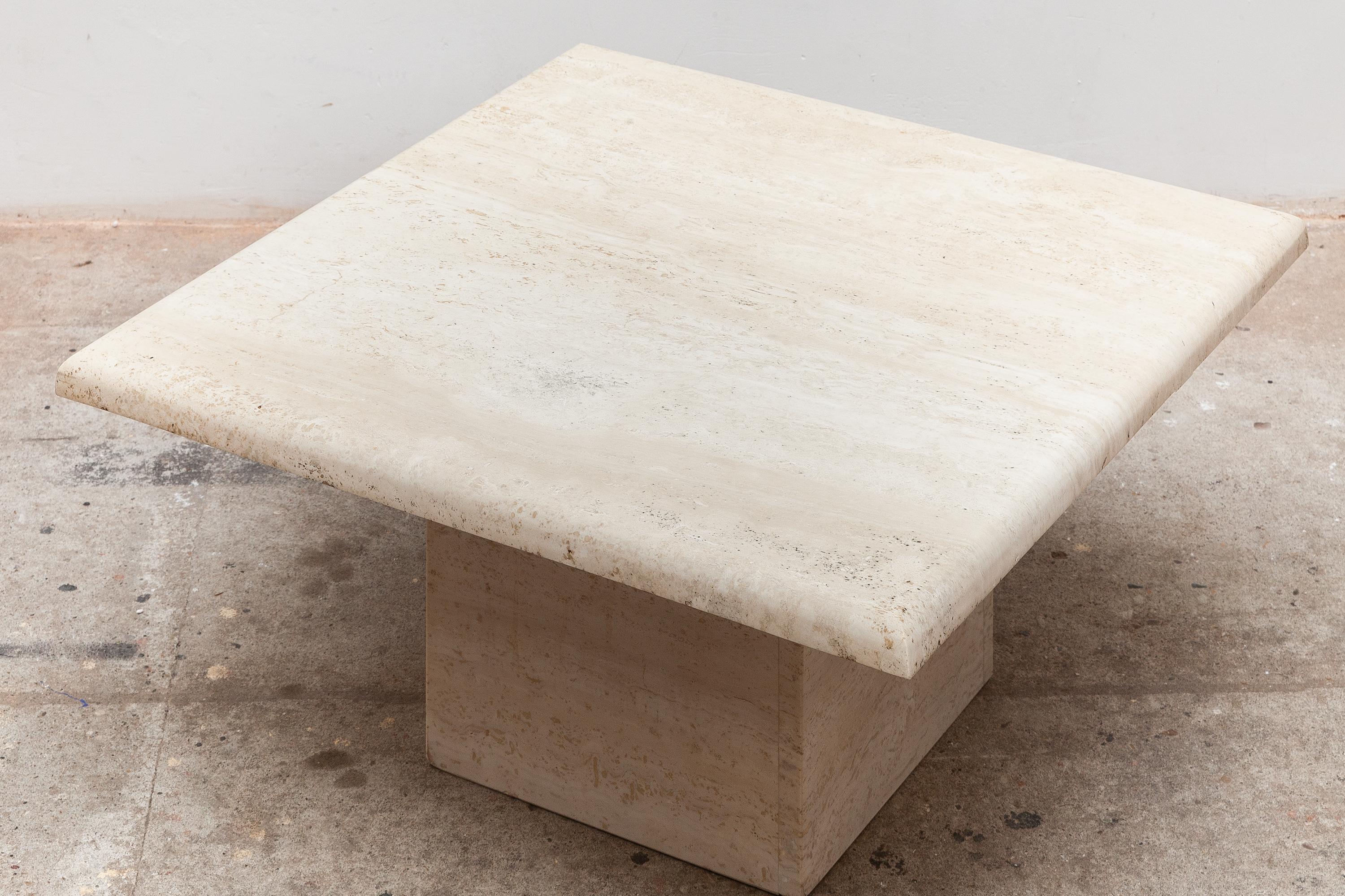 1970s travertine coffee table. Warm beige color stone. Square top with rounded edge and square base. Dimensions: 70 W x 33 H x 70 D cm. Very good original condition.