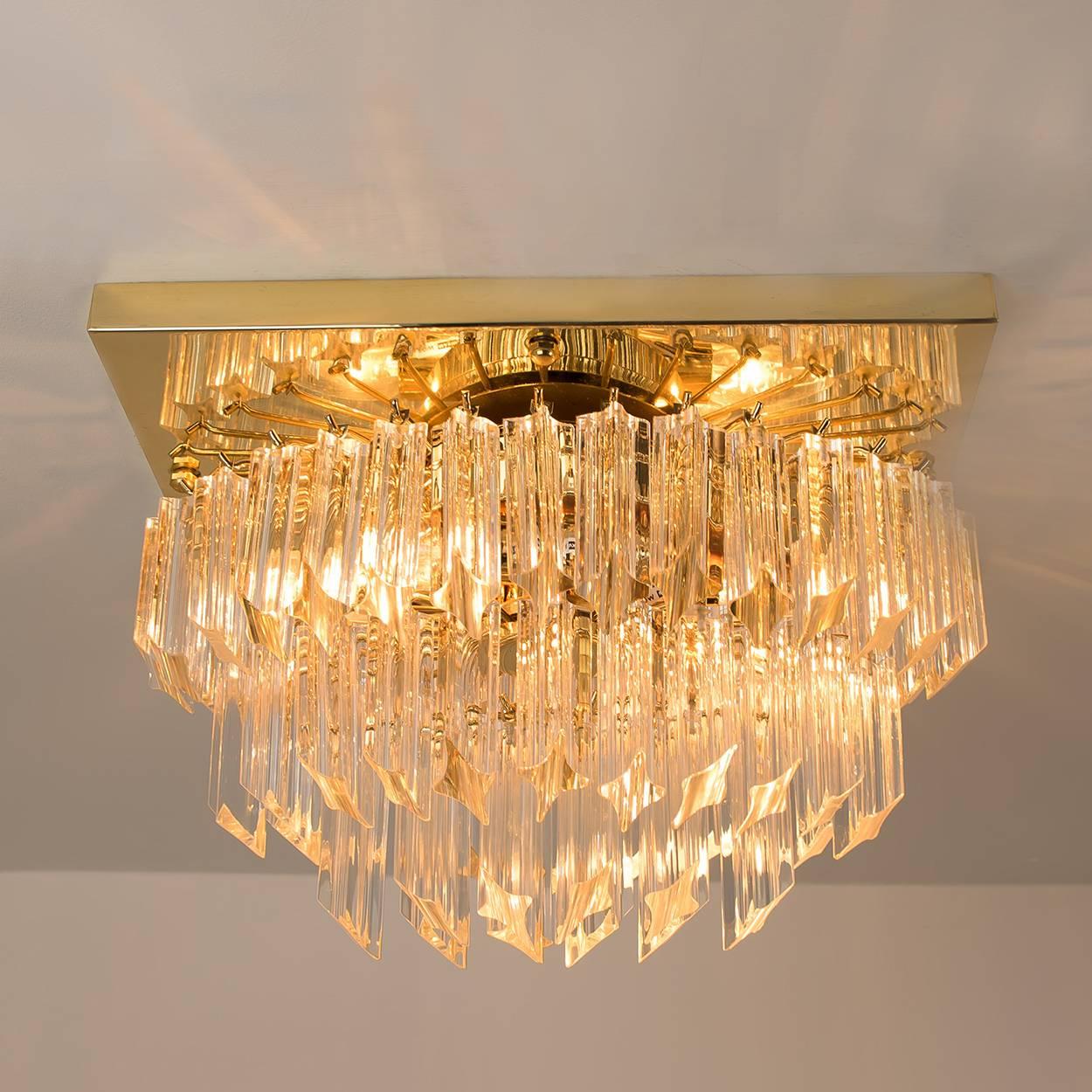 This stylish three-tiered faceted Murano flush mount with 58 clear crystal glass prisms was designed and produced by Venini in Italy from the 1970s. The Venin Murano prisms are suspended on a square gold-plated frame. The prisms sparkle with the