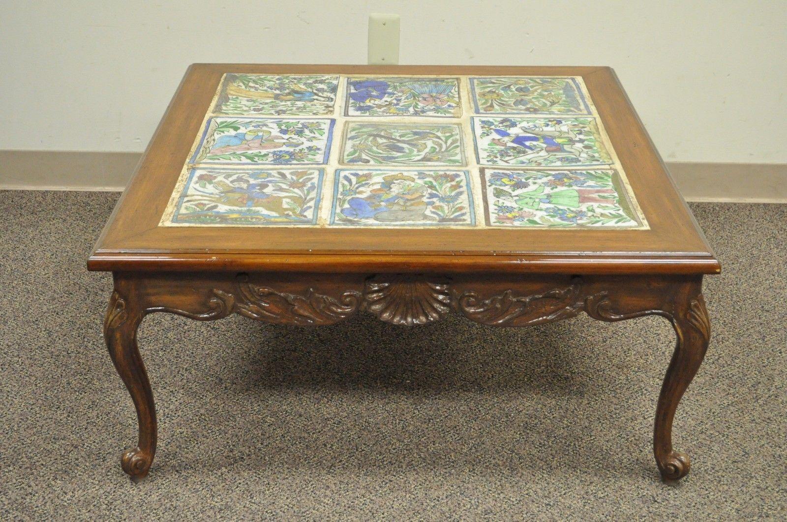 Vintage French country style tile top coffee table. Item features solid carved walnut frame, Louis XV style shell carved skirt, glazed ceramic tile top, Turkish / ottoman style depictions, amazing quality, circa mid-20th century. Measurements: 16