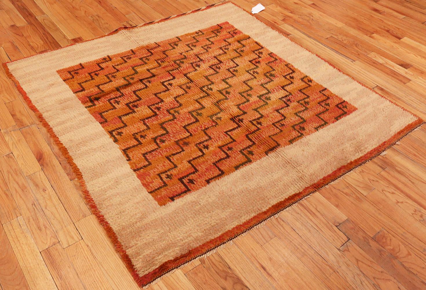 Scandinavian Swedish rug, Origin: Sweden, circa mid-20th century. Size: 5 ft 9 in x 5 ft 11 in (1.75 m x 1.8 m).

This lovely Swedish deco rug has a a stunning stepped geometry on a burnt orange ground set against a warm ivory-tan border. While