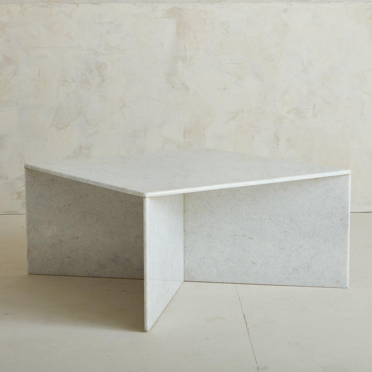 A vintage coffee table constructed with five .5” thick slabs of white crystalline marble. This table has a square tabletop on an attached X-base. The marble is a refined shade of white with subtle gray veining. Sourced in Italy, 1970s.

 