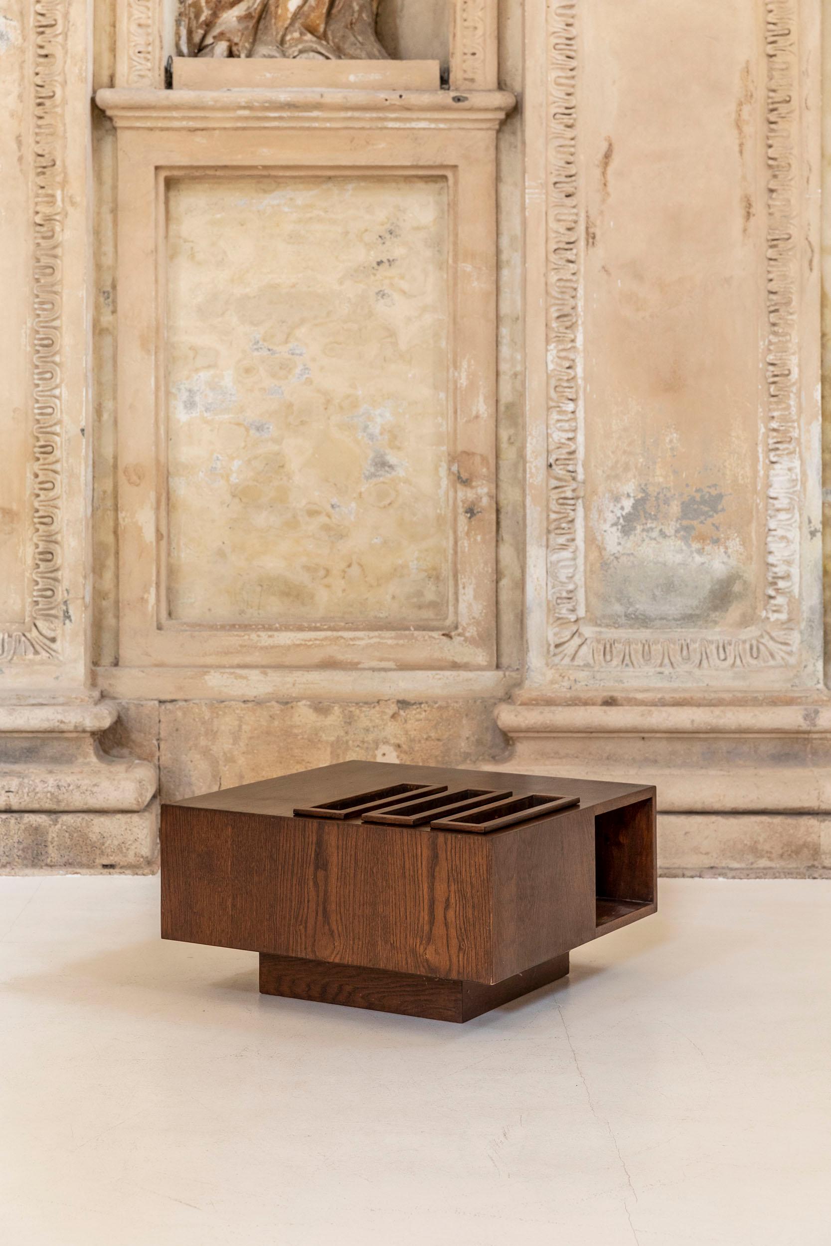 Squared coffee table attributed to Giuseppe Rivadossi, Italy, 1970’s. The modernistic appearance of this low table comes from the succession of full and empty geometrical elements. On the top surface, there are three framed fissures. The full oak