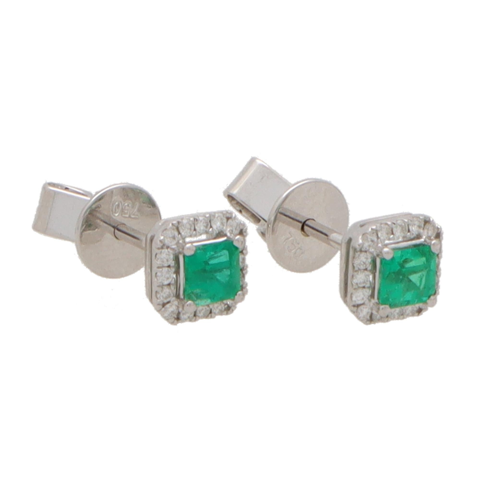  A beautiful pair of vibrant green emerald and diamond cluster earrings set in 18k white gold.

Each earring is composed is a square shape and centrally features a beautiful green square cut emerald which is four claw set securely. Surrounding each