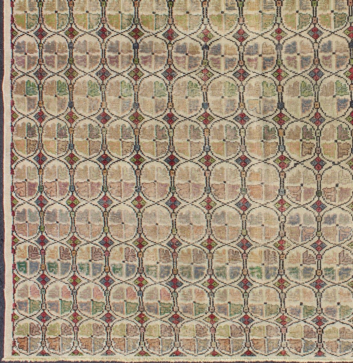 Tapis de taille carrée de style moderne du milieu du siècle avec un motif circulaire dans une variété de couleurs.
Rendu sur un fond sourd avec un assortiment tacheté et moucheté de jaunes, rouges, bruns, verts et bleus, ce tapis carré très unique