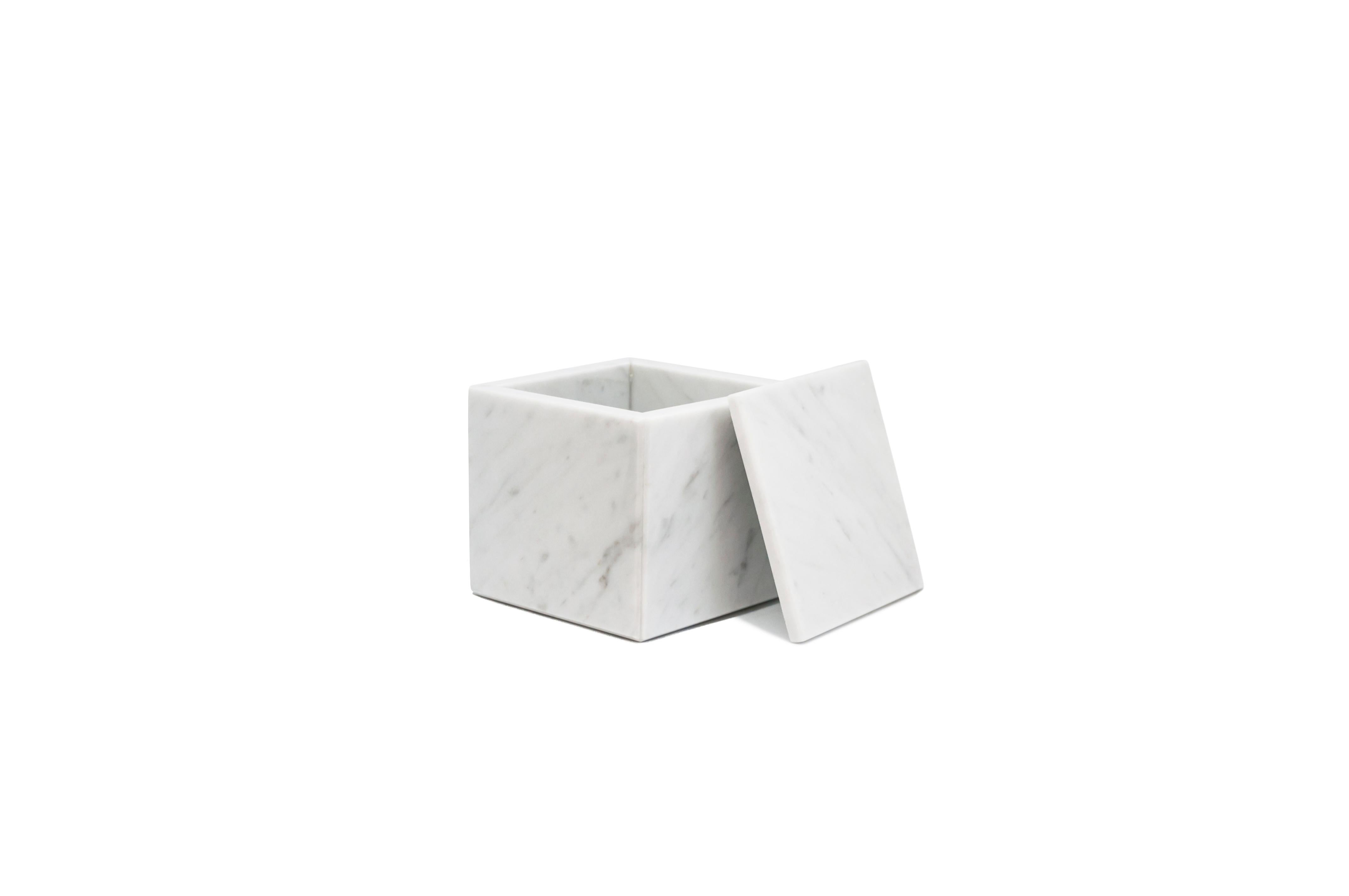 Squared white Carrara marble box with lid.
Each piece is in a way unique (since each marble block is different in veins and shades) and handcrafted in Italy. Slight variations in shape, color and size are to be considered a guarantee of an