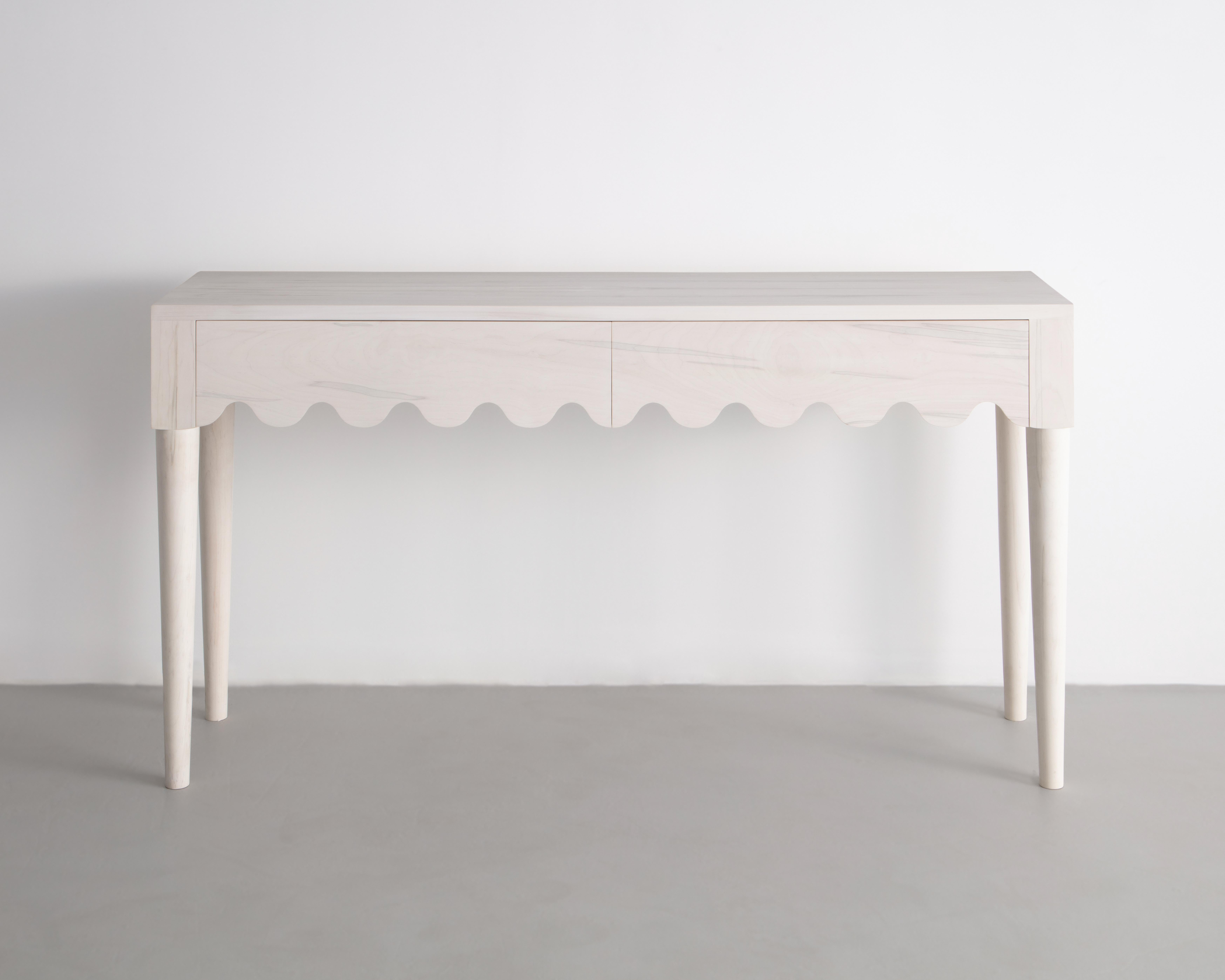 Designed and built in the studio this entryway table features a playful detail that continues along its double drawer faces and seamlessly wraps around its form. 

Made from solid Bleached Maple -inspired by the French mid-century designer Jean