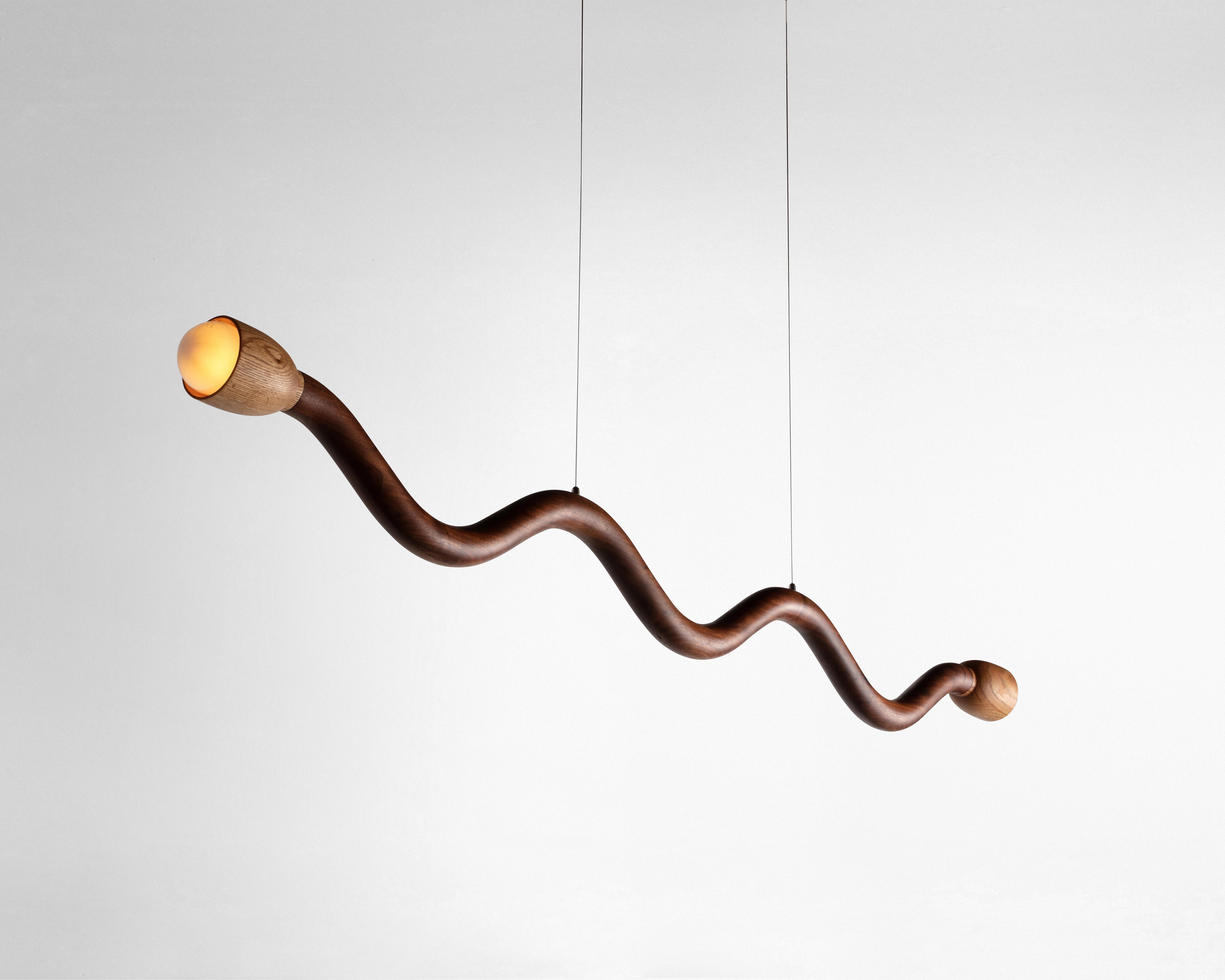 The Squiggle light was created though an exploration of shaping solid walnut slab lumber. Designed to bring a smile to any space, each light is thoughtfully selected to highlight the grain pattern and characteristics of American black walnut. Each