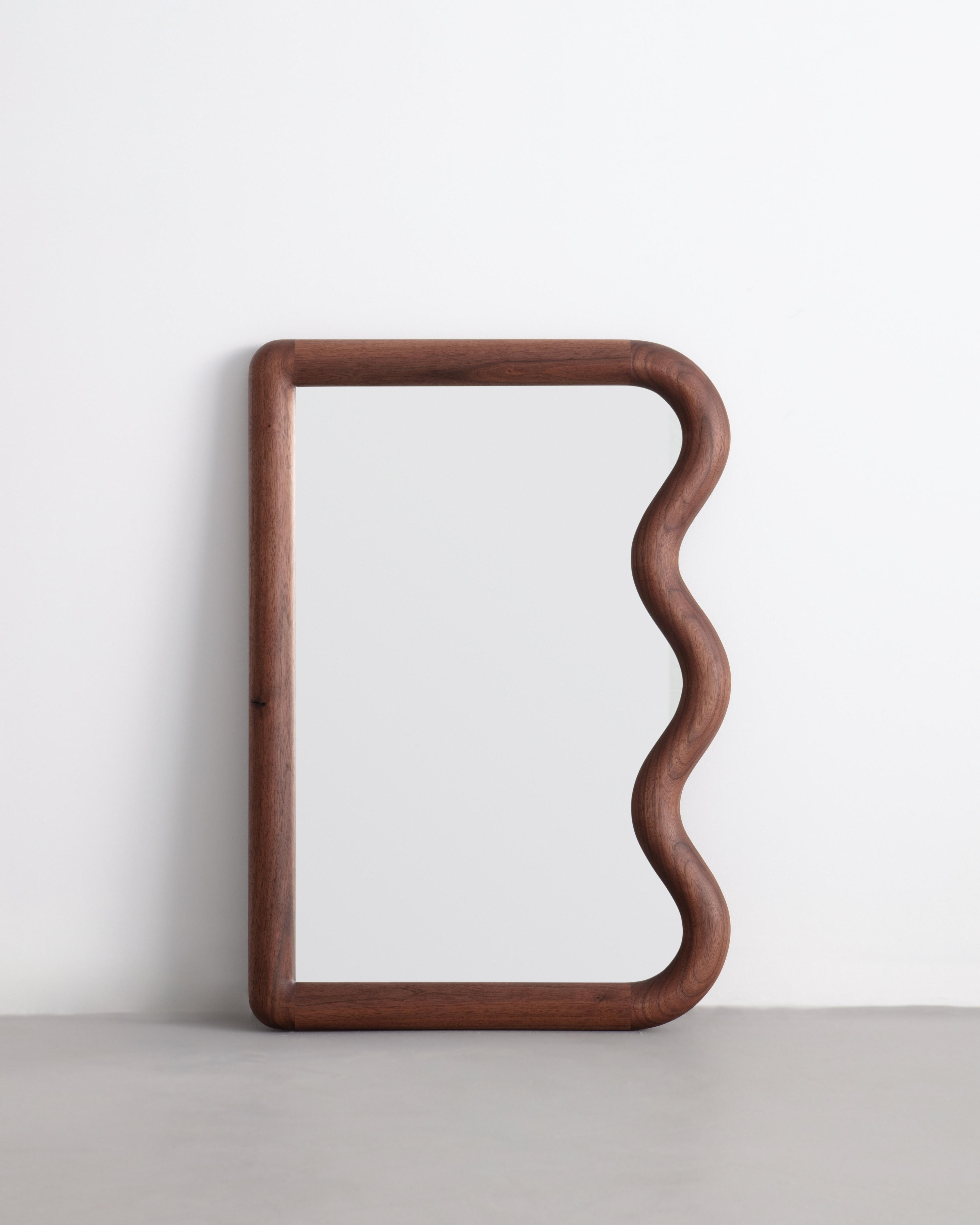 Constructed from Solid American Black Walnut this mini Squiggle Mirror is made to order. The mirror can be hung vertically by its custom french cleat.

Mirror can be placed leaning or hung.