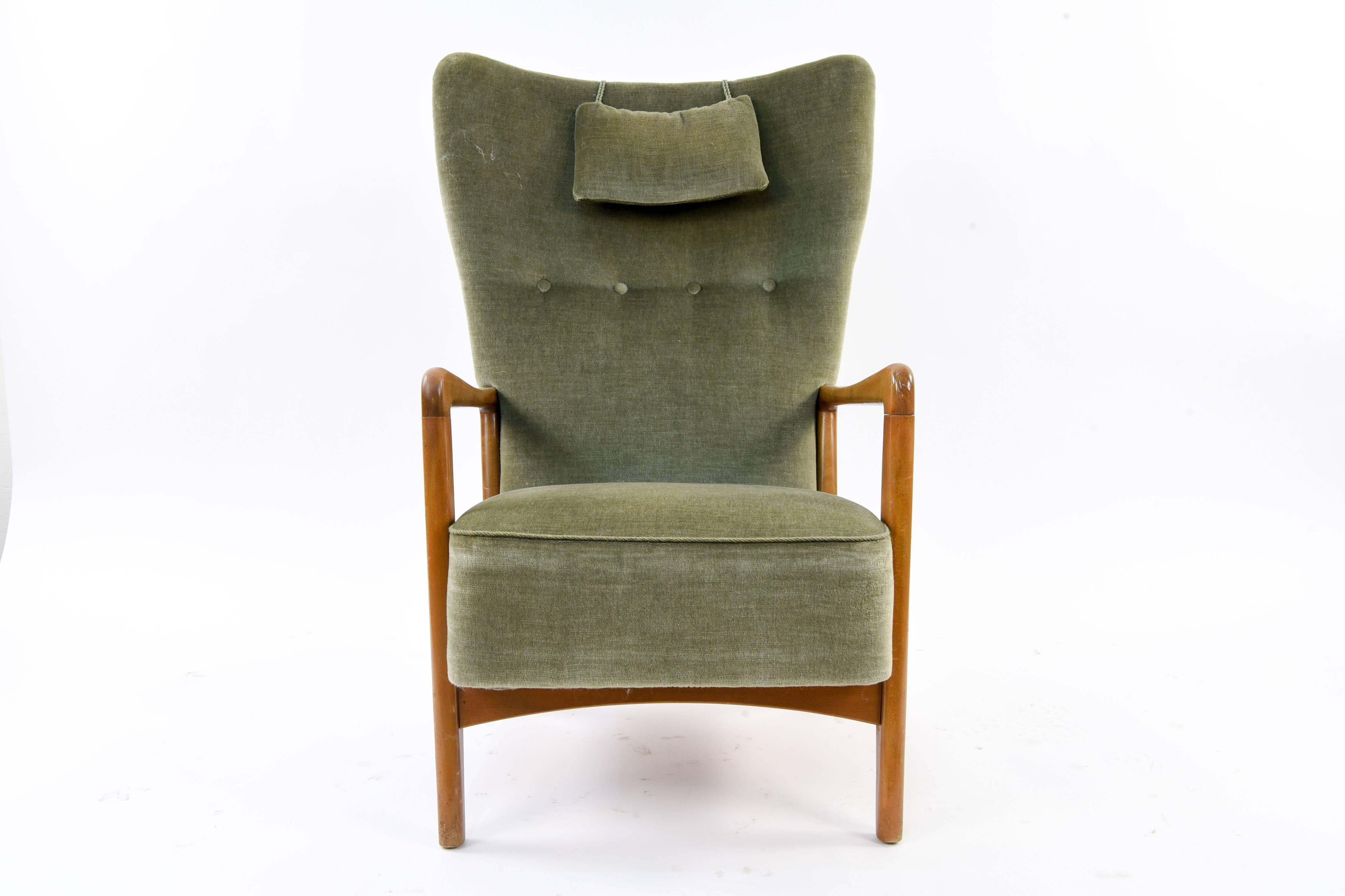 This midcentury Danish lounge chair is upholstered in a lovely olive toned fabric. Designed by Soren Hansen for Fritz Hansen, circa 1940s. Features a tufted back and removable head rest pillow.