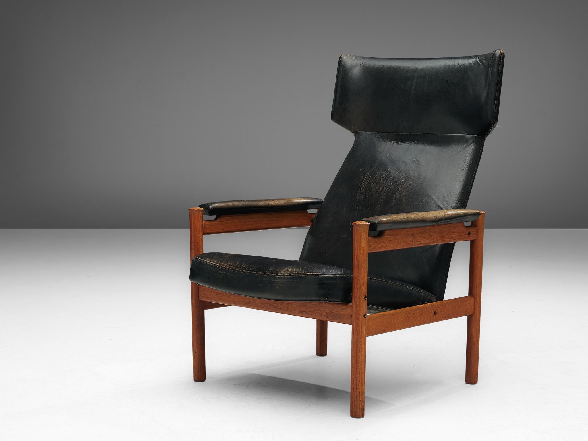 Søren Hansen for Fritz Hansen, model 4365 wingback chair, in teak and black leather, Denmark, 1960s. 

This chair, designed by Søren Hansen, is a Scandinavian Modern interpretation of the classic wing chair. The chair has a strong, robust appearance