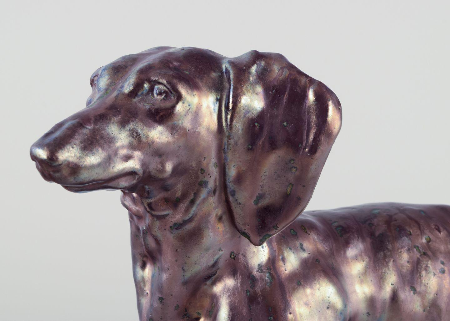 Pre-owned goods are exempt from import duties for U.S. customers. 
Therefore, no import tariffs will be applicable to your purchase.

Søren Kongstrand (1872-1951), Danish ceramicist.
Large sculpture of a dachshund in lustre glaze. One of a