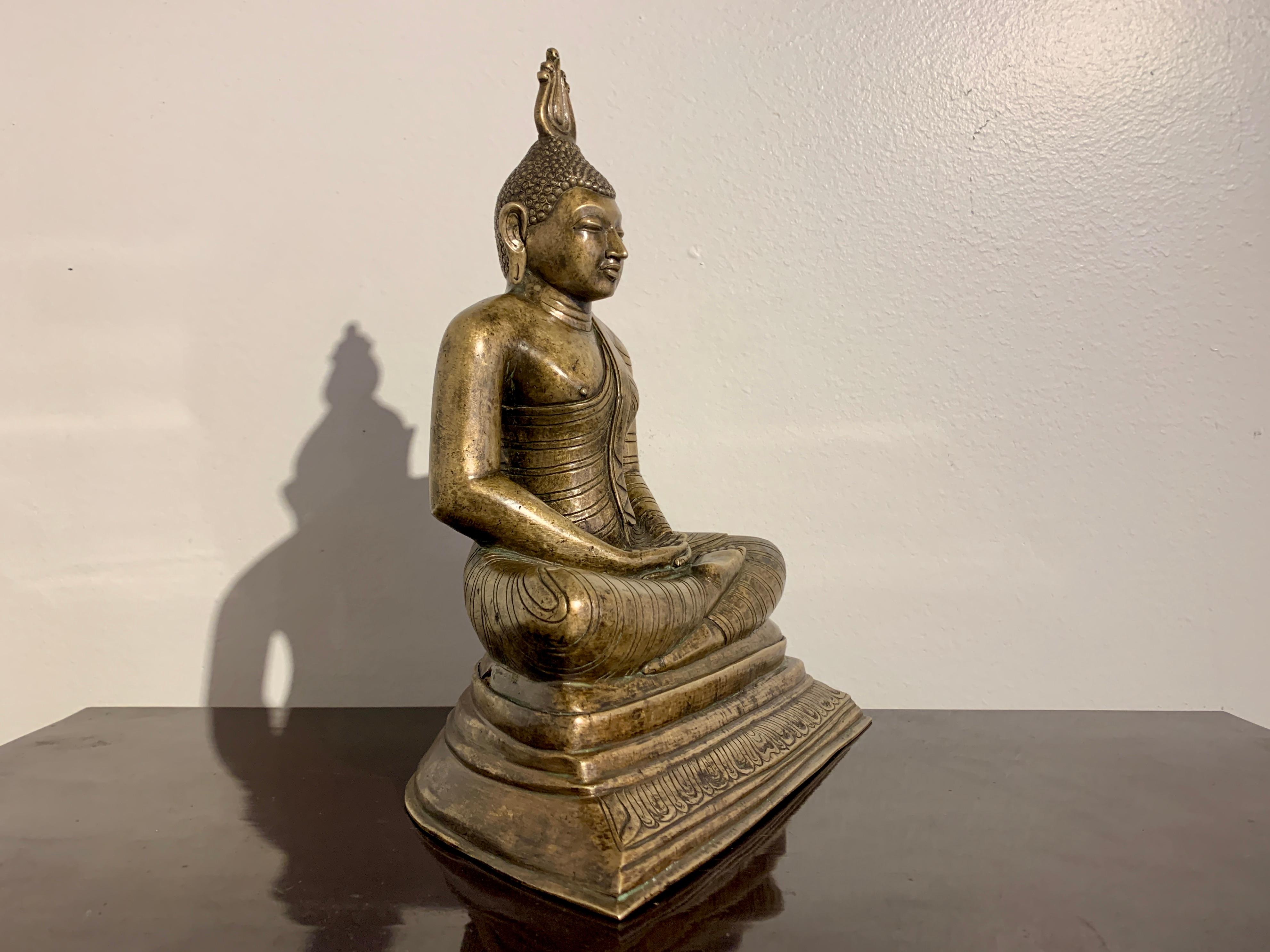 Grande et lourde image en bronze bien coulée du Bouddha assis en méditation, fin ou juste après la période Kandyan (1597 - 1815), début ou milieu du XIXe siècle, Sri Lanka.

Le Bouddha est assis sur une base trapézoïdale à plusieurs niveaux, avec