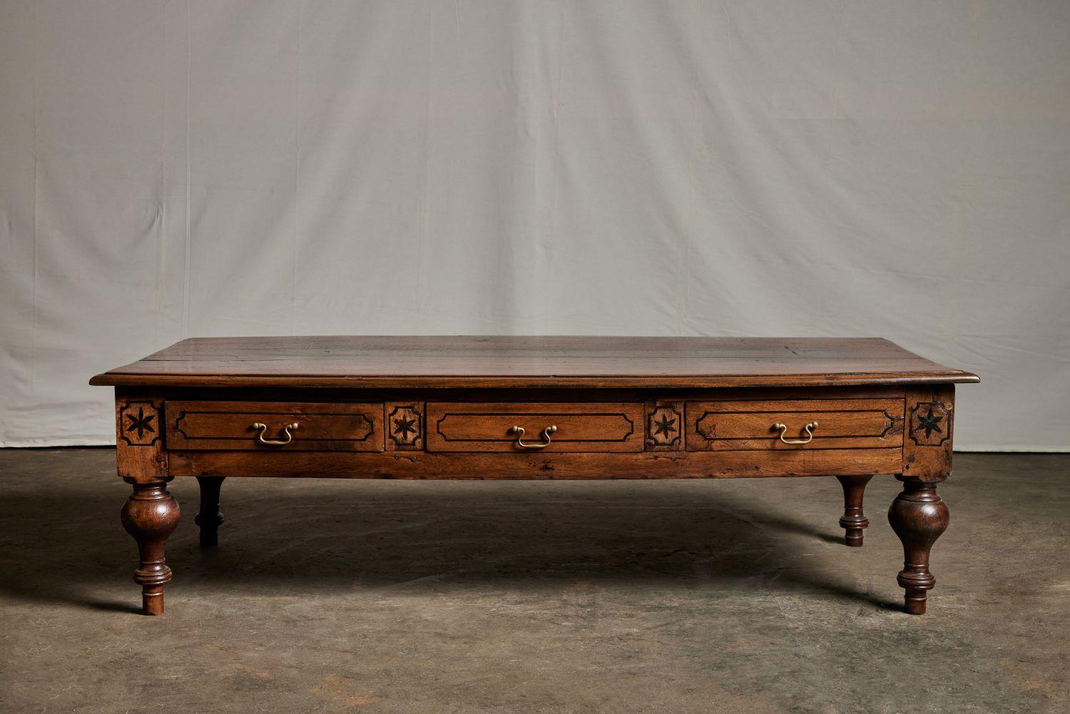 Sri Lankan coffee table with three Drawers and metal handles. Sides of drawers have intricate leaf carvings.
