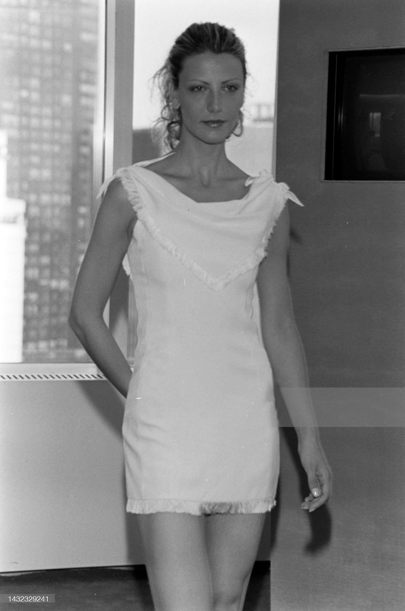 A stunning Dior by John Galliano off-white dress from 1998 Resort collection, with an elegant draped collar and a fringe trim. The draping on one side has a closure that allows to also style the collar asymmetrically with one cold shoulder.

Size FR