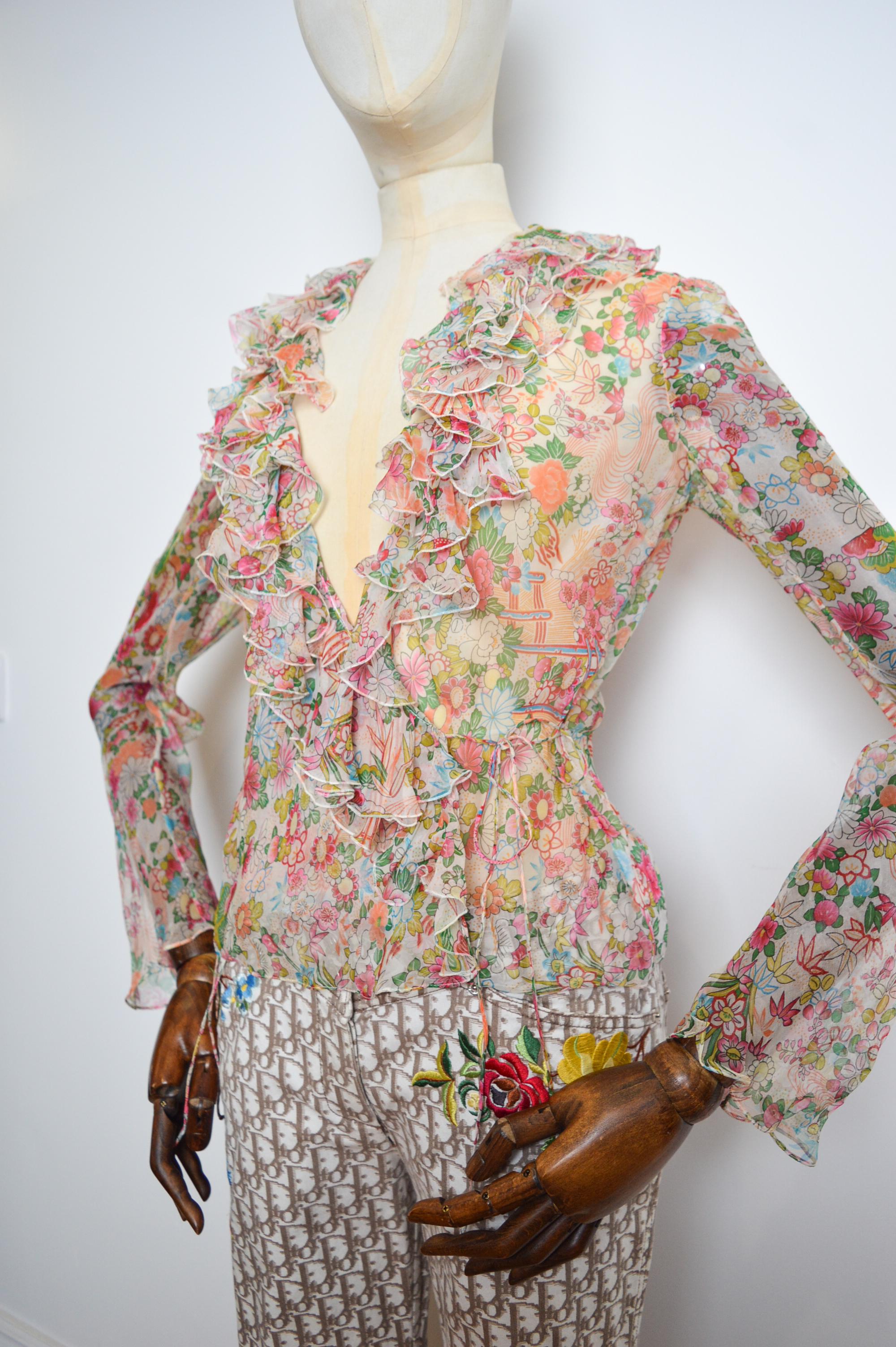 A Beautiful Delicate Spring / Summer 2002 ruffled, Chiffon blouse by John Galliano for Christian Dior. 

Intricately adorned with a cherry blossom print. 

100% Silk

MADE IN FRANCE.

Measurements in Inches - 
Pit to Pit -17