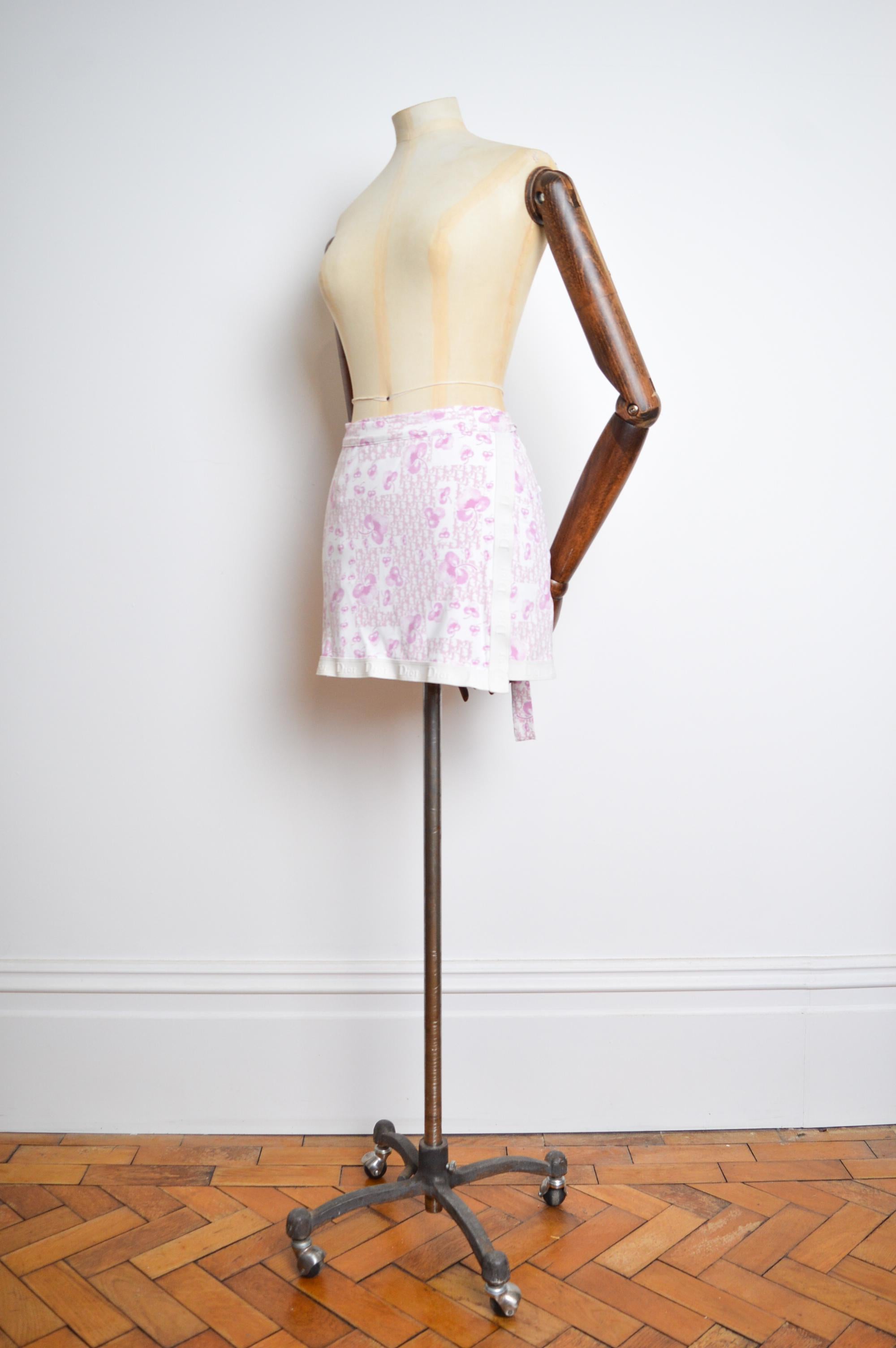 Spring / Summer 2005 Christian Dior by John Galliano Mini Wrap around skirt.

This iconic Vintage 2000's Mini skirt comes in the iconic 'Girly Trotter' print in a Pastel pink and white colour way.

MADE IN ITALY.

Measurements are provided in Inches