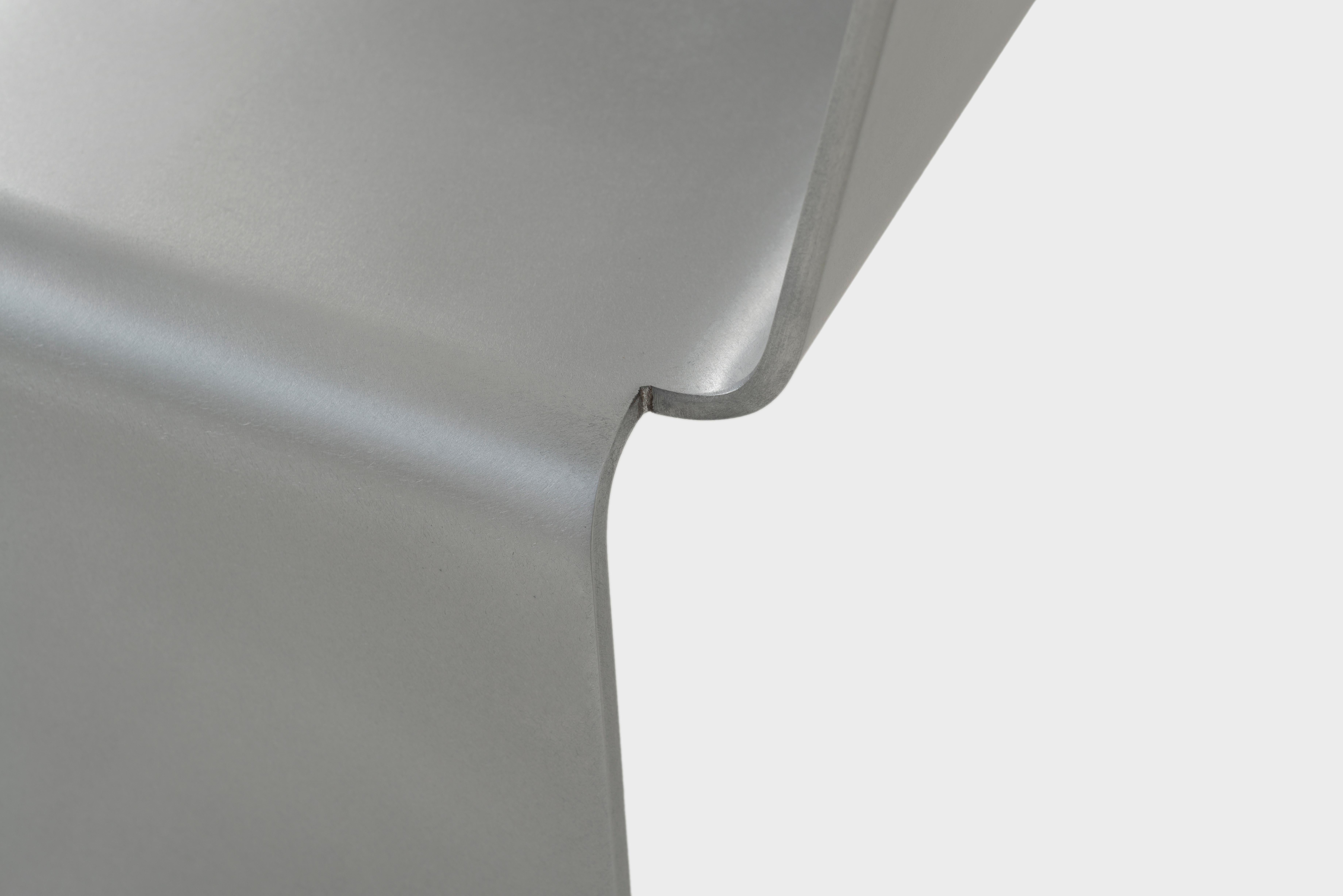 Le banc SS de Jonathan Nesci en plaque d'aluminium d'un quart de pouce coupée, formée et cirée. Une pièce de métal à trois coudes crée un dossier et des pieds. Chaque œuvre est finie à la main et cirée. La forme est disponible en largeur de chaise