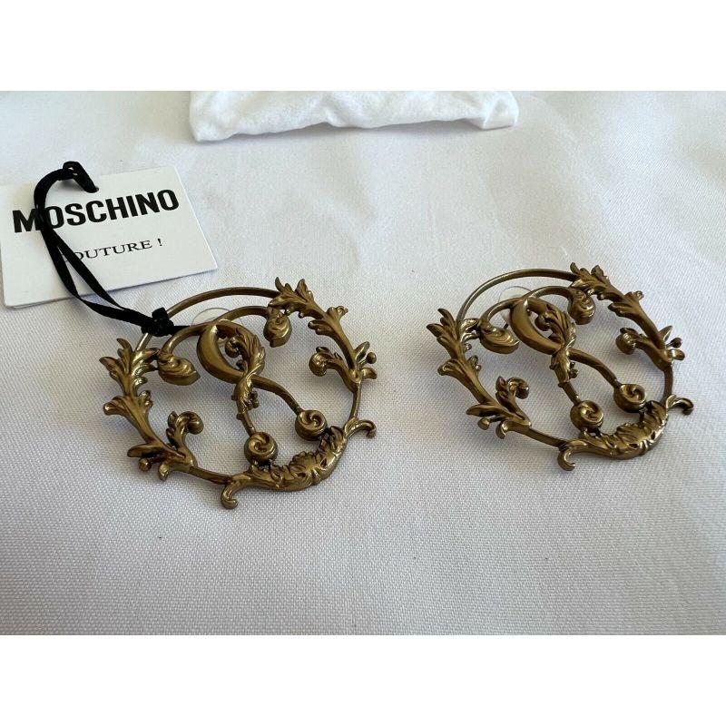 SS19 Moschino Couture Jeremy Scott Logo W/ 'Shrubs on Metal Gate' Gold Earrings

Additional Information:
Material: Metal
Color: Metallic Gold Material: Fibre/metal.
Pattern: Logo with 'shrubs climbing a metal gate'
Style: Hoop  
100%