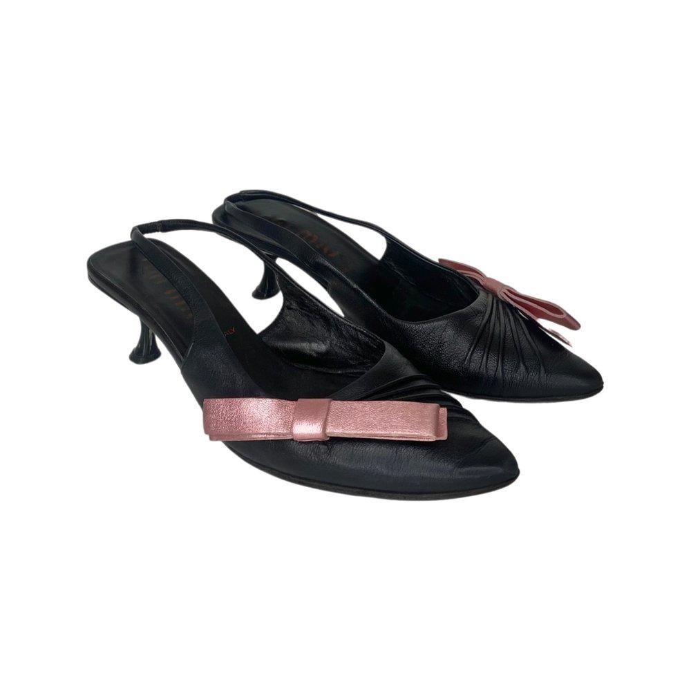 Vintage black leather Miu Miu slingback mules with bow detailing in pink satin. Featured in the Spring Summer 2000 runway and campaign imagery. Miu Miu logo engraved to the soles, heels and printed on the foot beds.

Period
Spring Summer