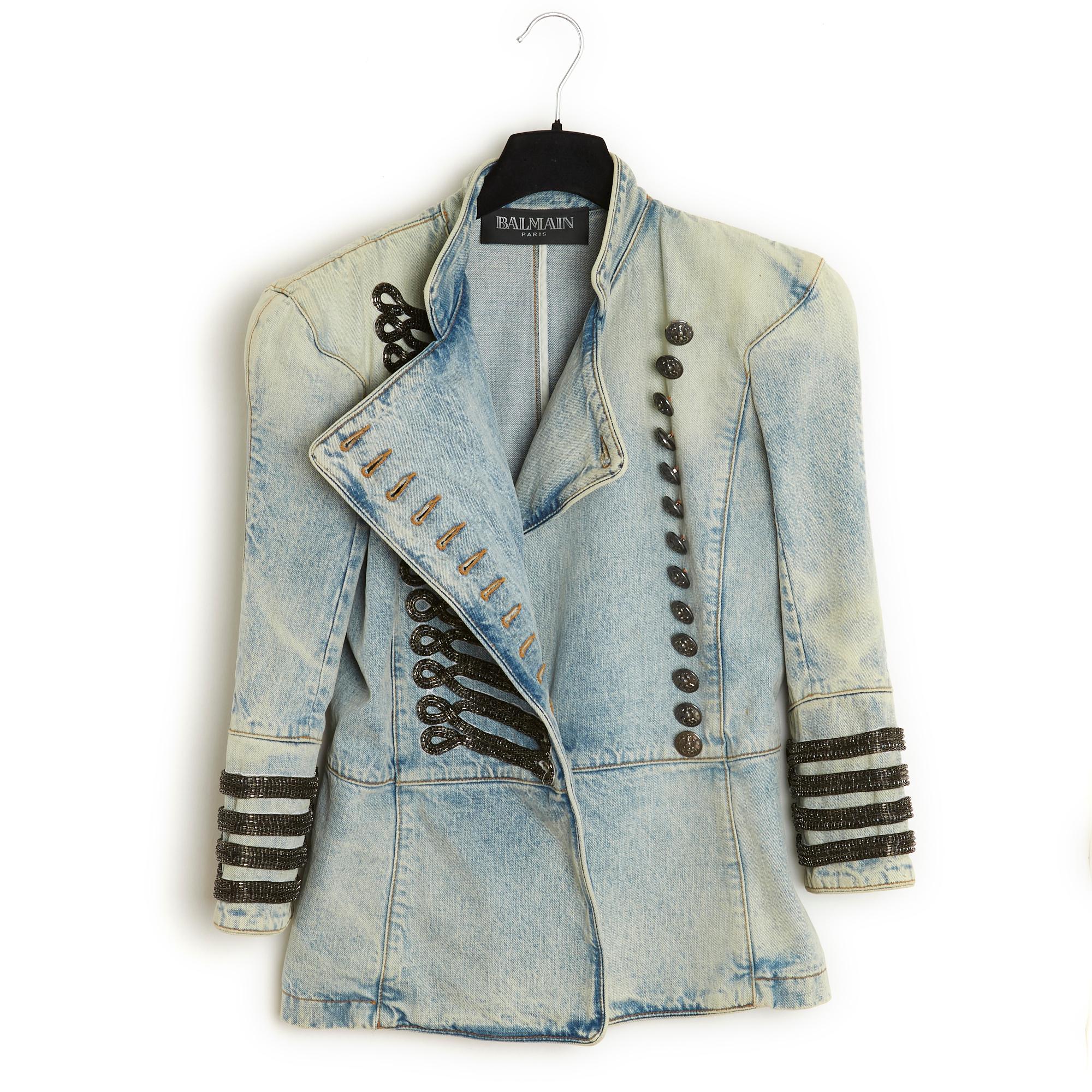 Balmain jacket SS2009 collection by Christophe Decarnin, military inspiration, in washed denim, small stand-up collar, bib decorated with blackened metal chain trimmings closed on 13 branded buttons, shoulder pads, 2/3 slit sleeves decorated with