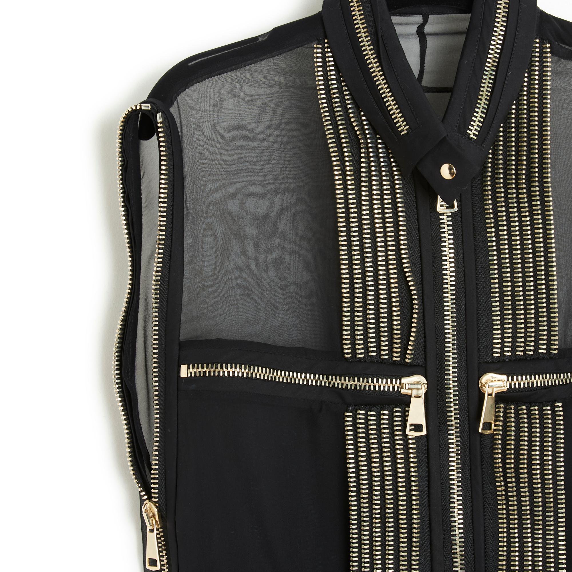 Givenchy top SS 2011 collection (by Riccardo Tisci) in black silk chiffon embroidered with silver metal zips, small high collar closed with a snap, long front zip, 2 zipped pockets on the chest and zips on each side to open or close. Size 42FR but