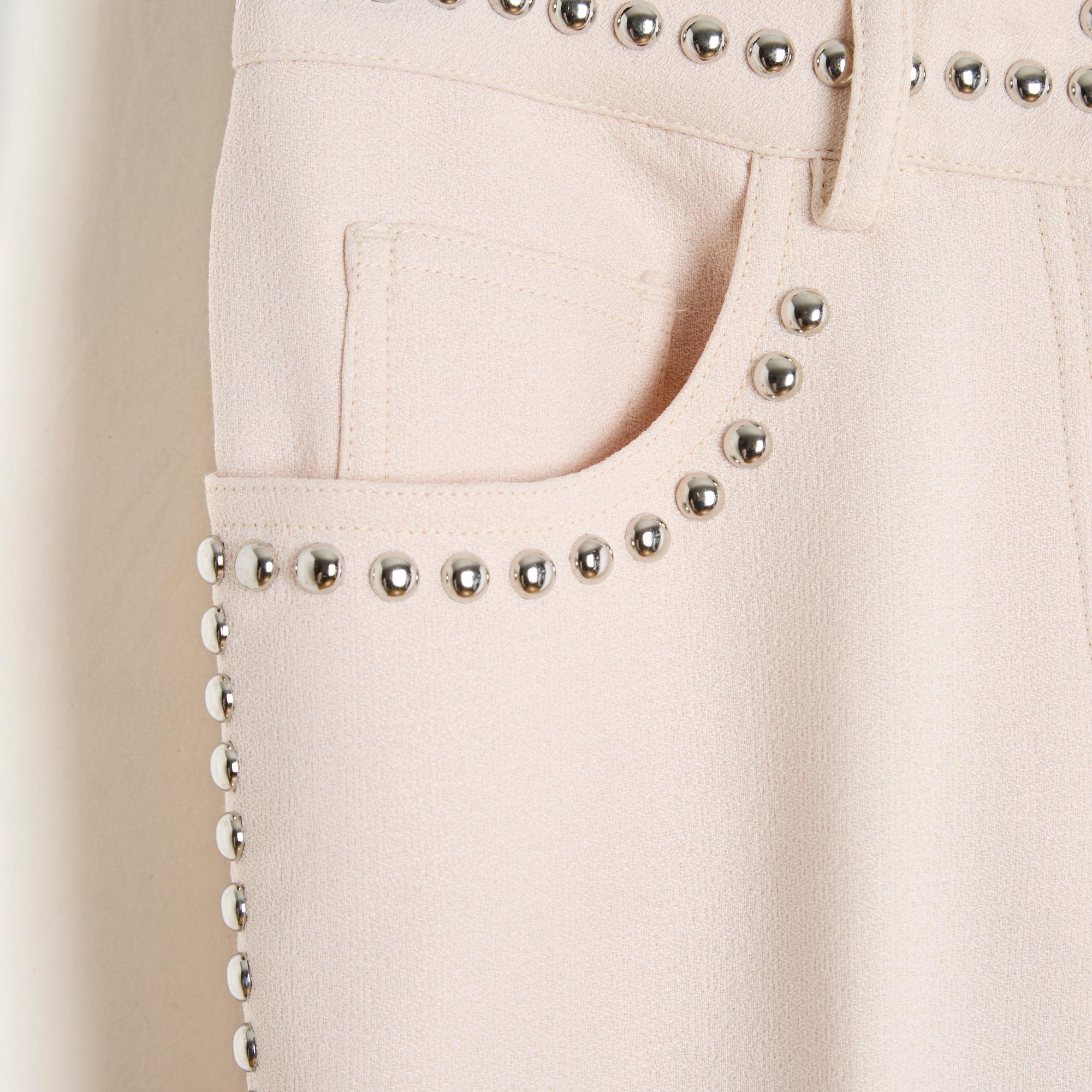 Giambattista Valli pants SS2009 collection in very pale pink viscose crepe and cotton, flare cut, decorated with round silver metal studs on the sides, on the belt and pockets, jean pockets, belt with loops, closed with a zip and a hook , unlined.