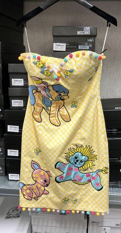 SS22 Moschino Couture Jeremy Scott - Vestito da bambino con orlo a griglia gialla e fantasia di pom pom