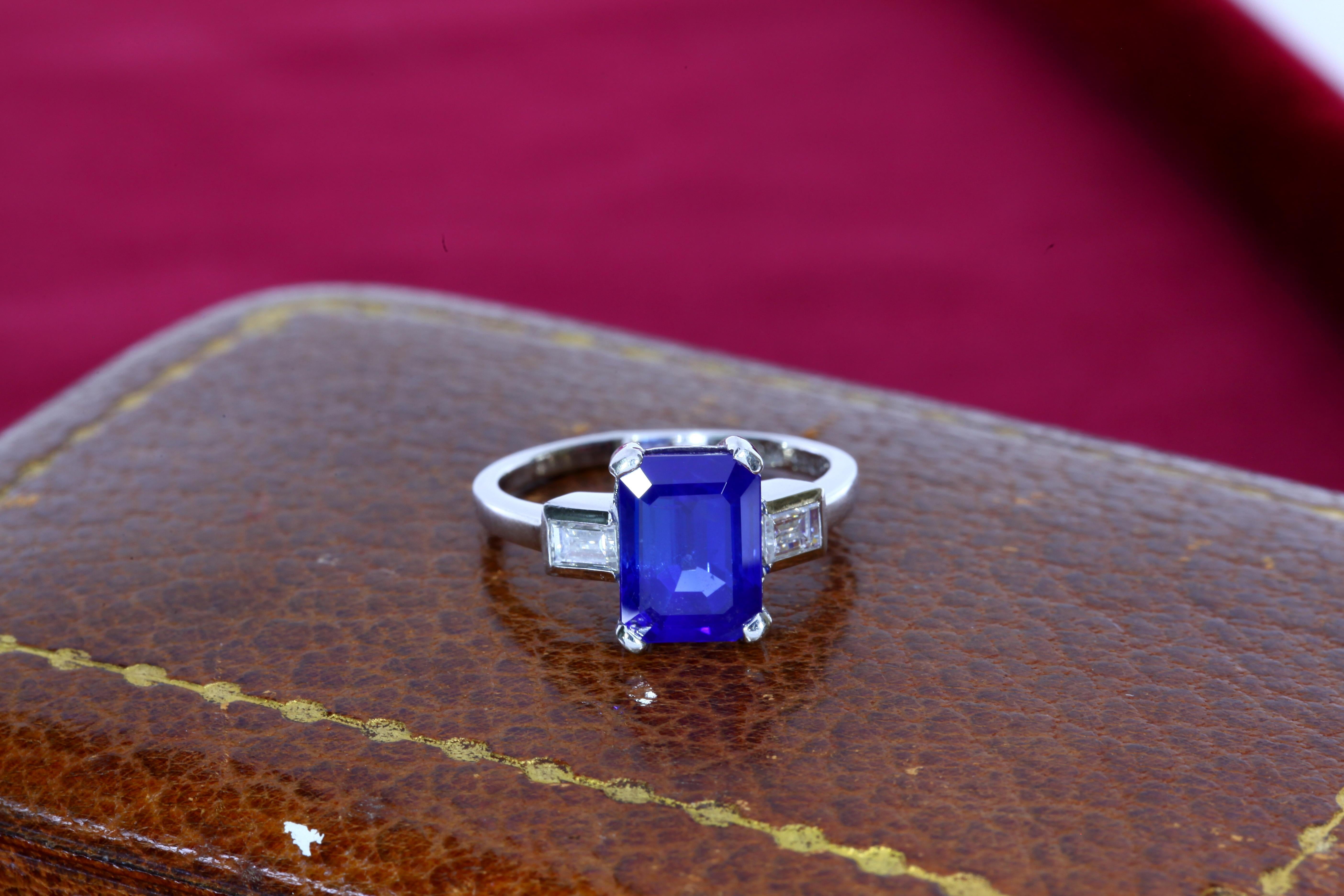 This untreated sapphire weighing 4.16 carats from the Kashmir region displays the velvet blue color typical of sapphires from this region. The sapphire is flanked by two baguette shaped diamonds and is mounted in a platinum ring. The center stone is