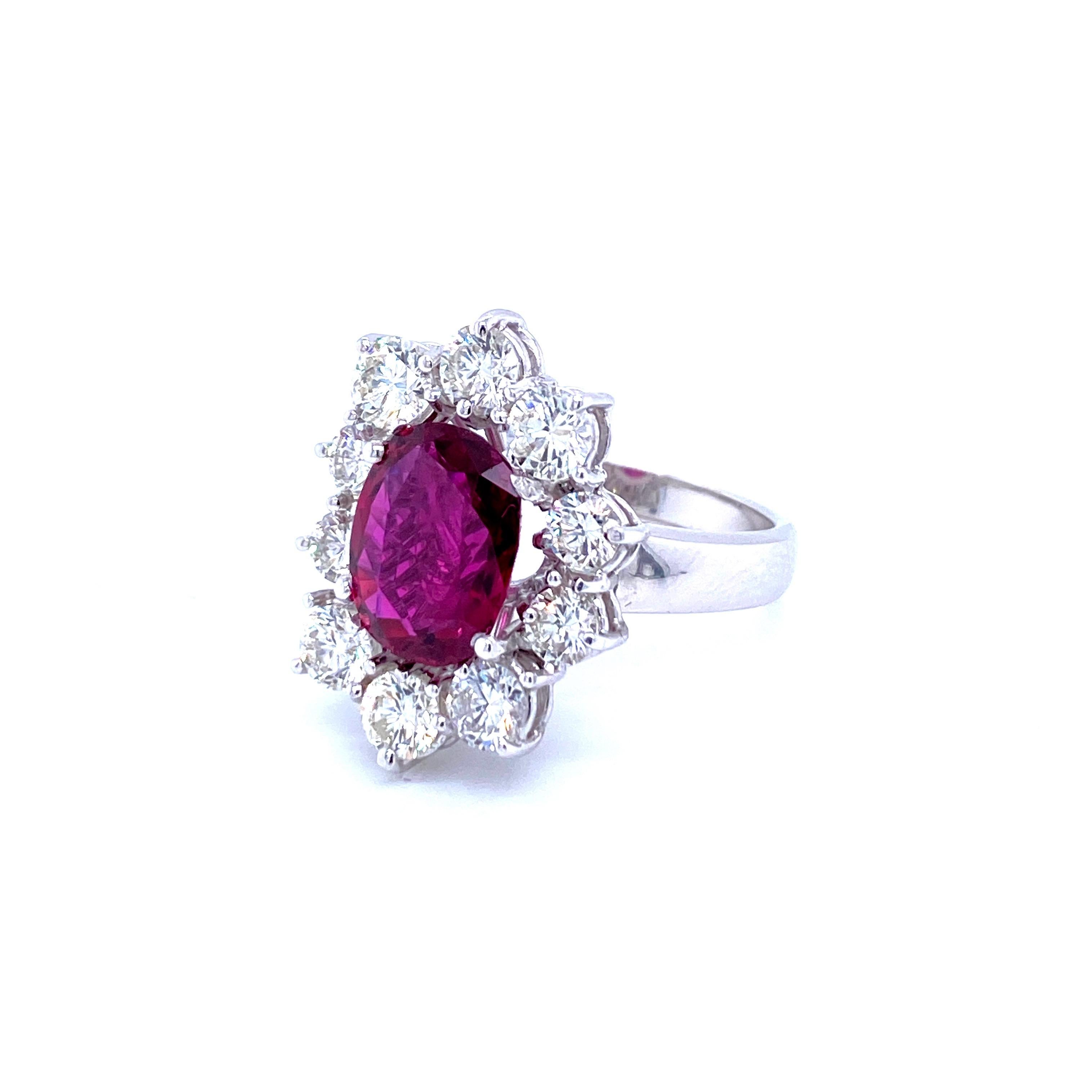 This beautiful 18k white Gold cluster ring features a 3.81 Carat oval-cut Ruby, origin Thailand, with a vibrant and rich purplish red color flanked by 10 round brilliant cut Diamonds for a total approx. weight of 3.00 carats color G  Vvs
