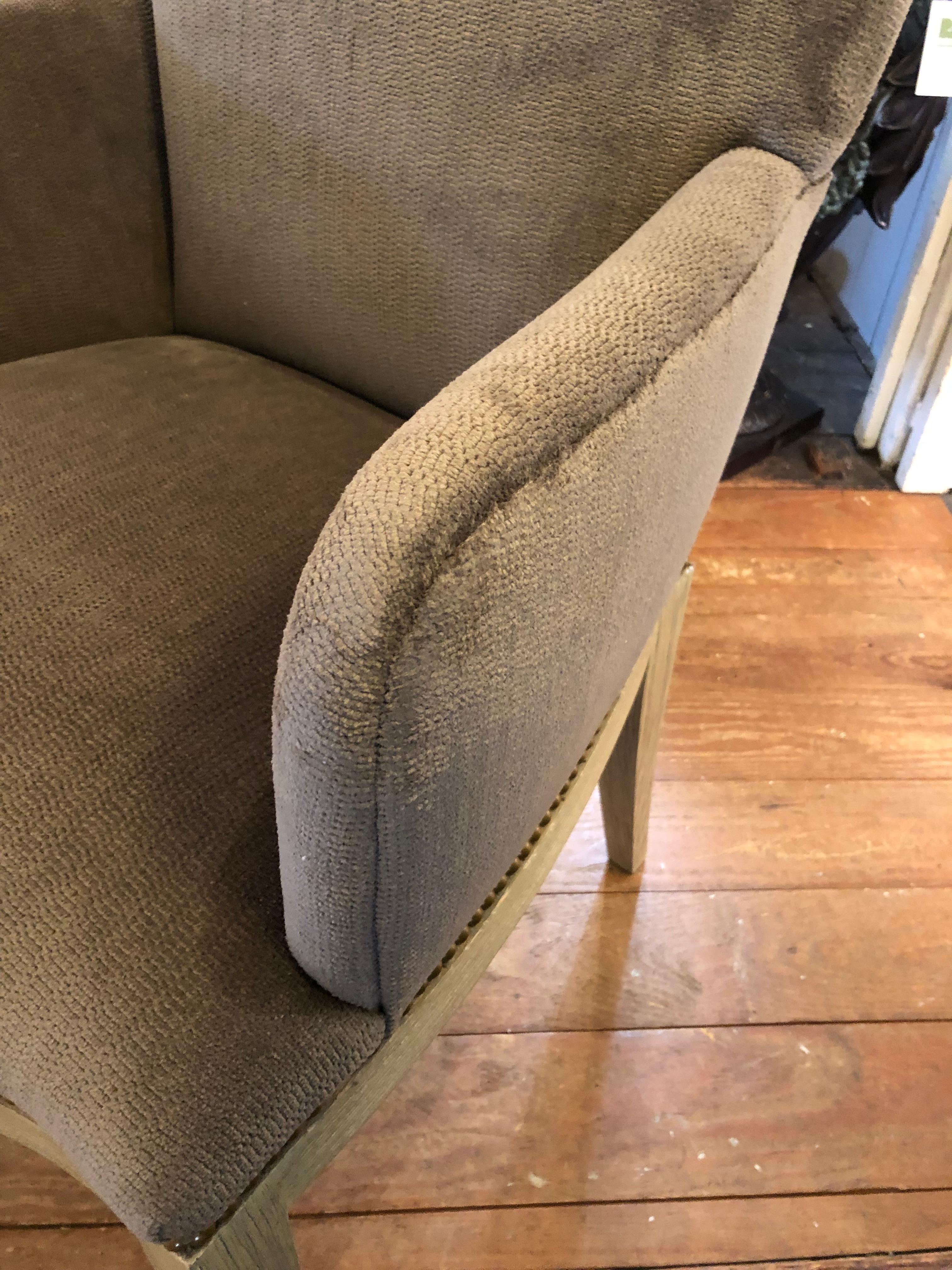 Stylish pair of newly upholstered luxe grey chenille armchairs having matte bras nailheads and cerused wood bases.
arm height 26