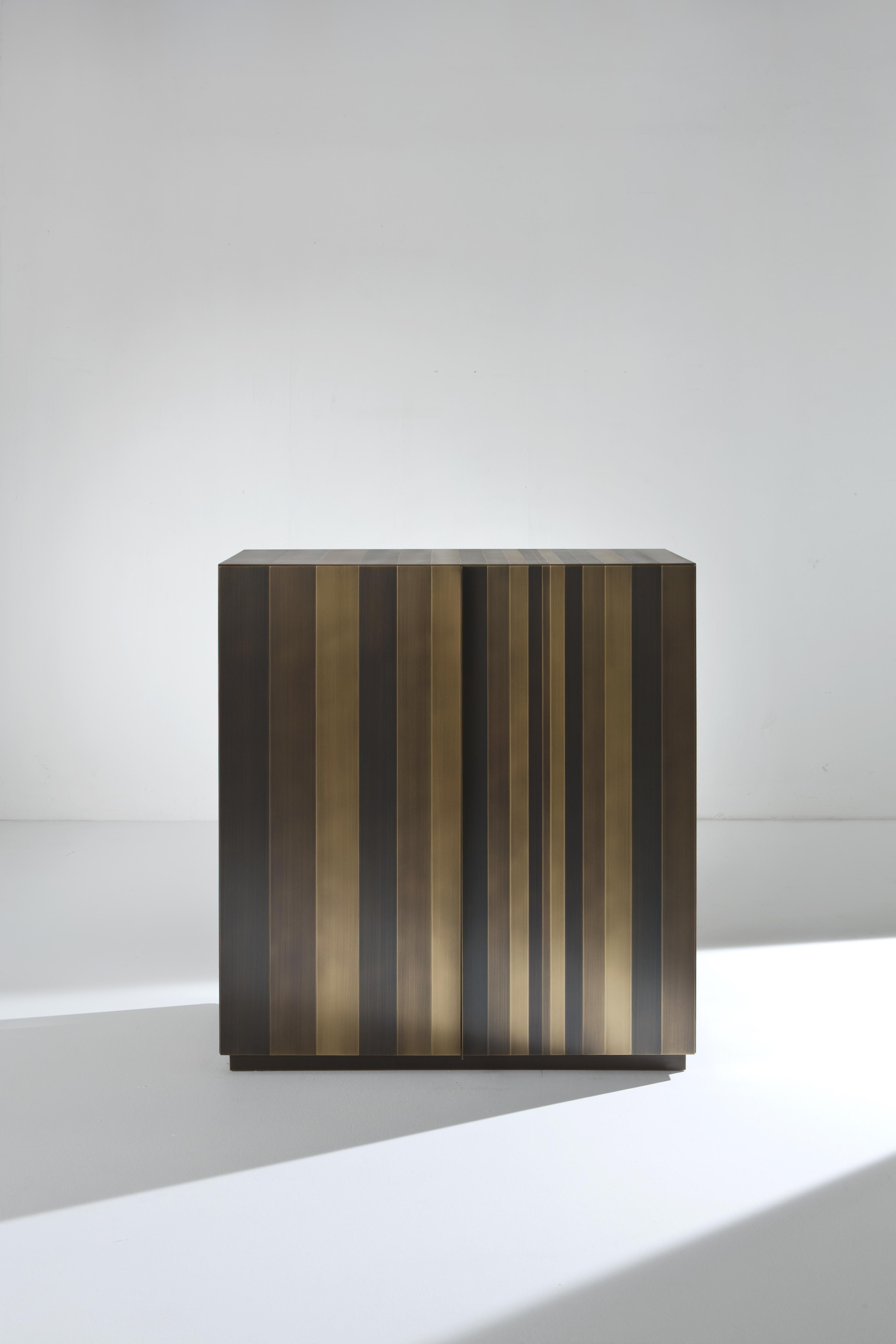 ST 01 Sideboard by Laurameroni
Dimensions: W 118 x D 50 x H 123 cm
Materials: Burnished brass + int. walnut Colore. 

Tall sideboard with 2 hinged doors, equipped with 3 internal drawers and 1
shelf. Side panels, doors, top and plinth clad in